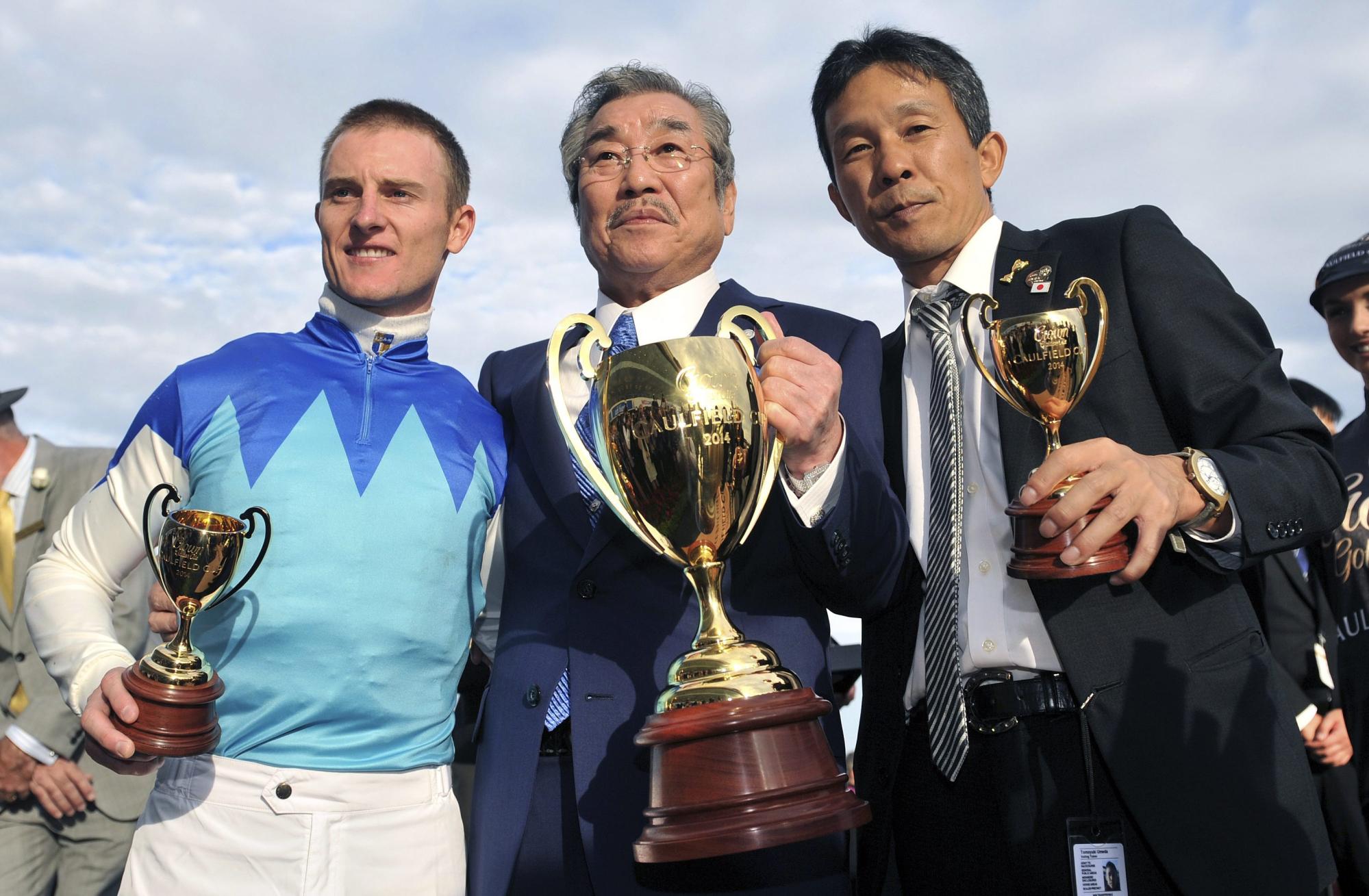 Zac Purton celebrates his Caulfield Cup win with connections.