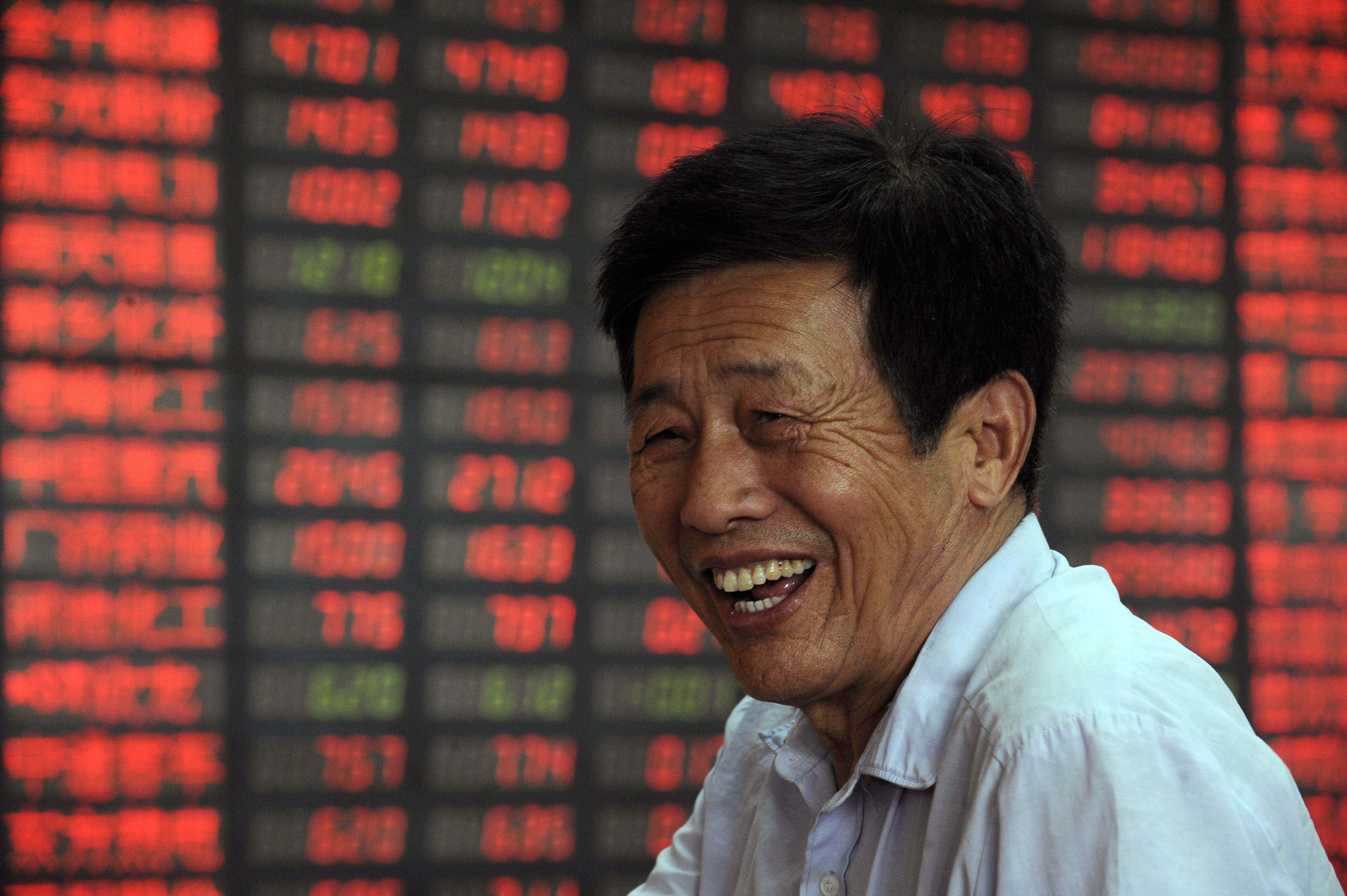 A trader at a brokerage house in Taiyuan in Shanxi province on August 3, 2009. Contrary to global conventions, China represents gains and advances in red, using the green colour to denote losses and declines. Photo: Reuters