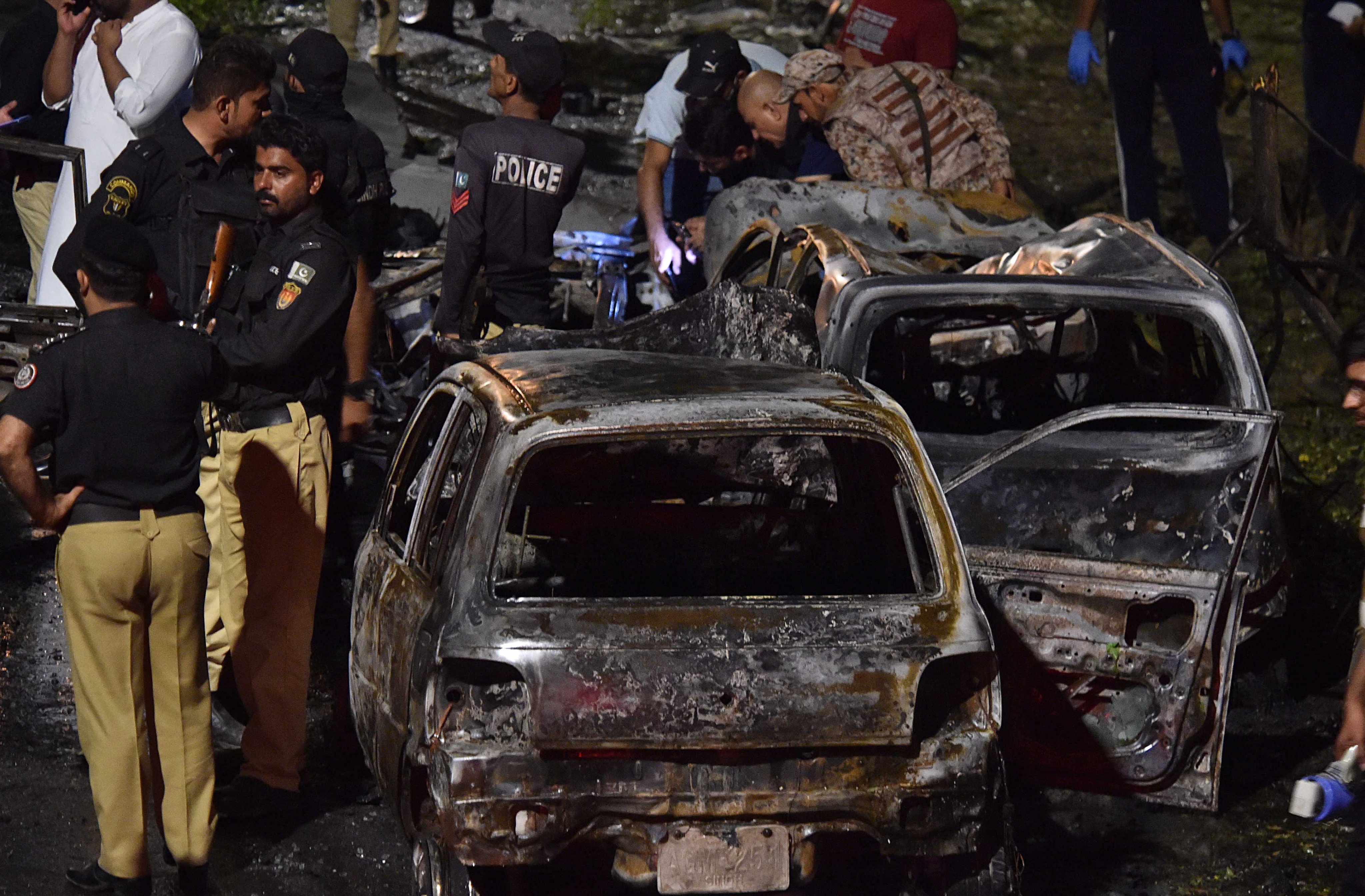 Pakistani security officials on Monday inspect the scene of the blast outside the Jinnah international airport in Karachi. Photo: EPA-EFE