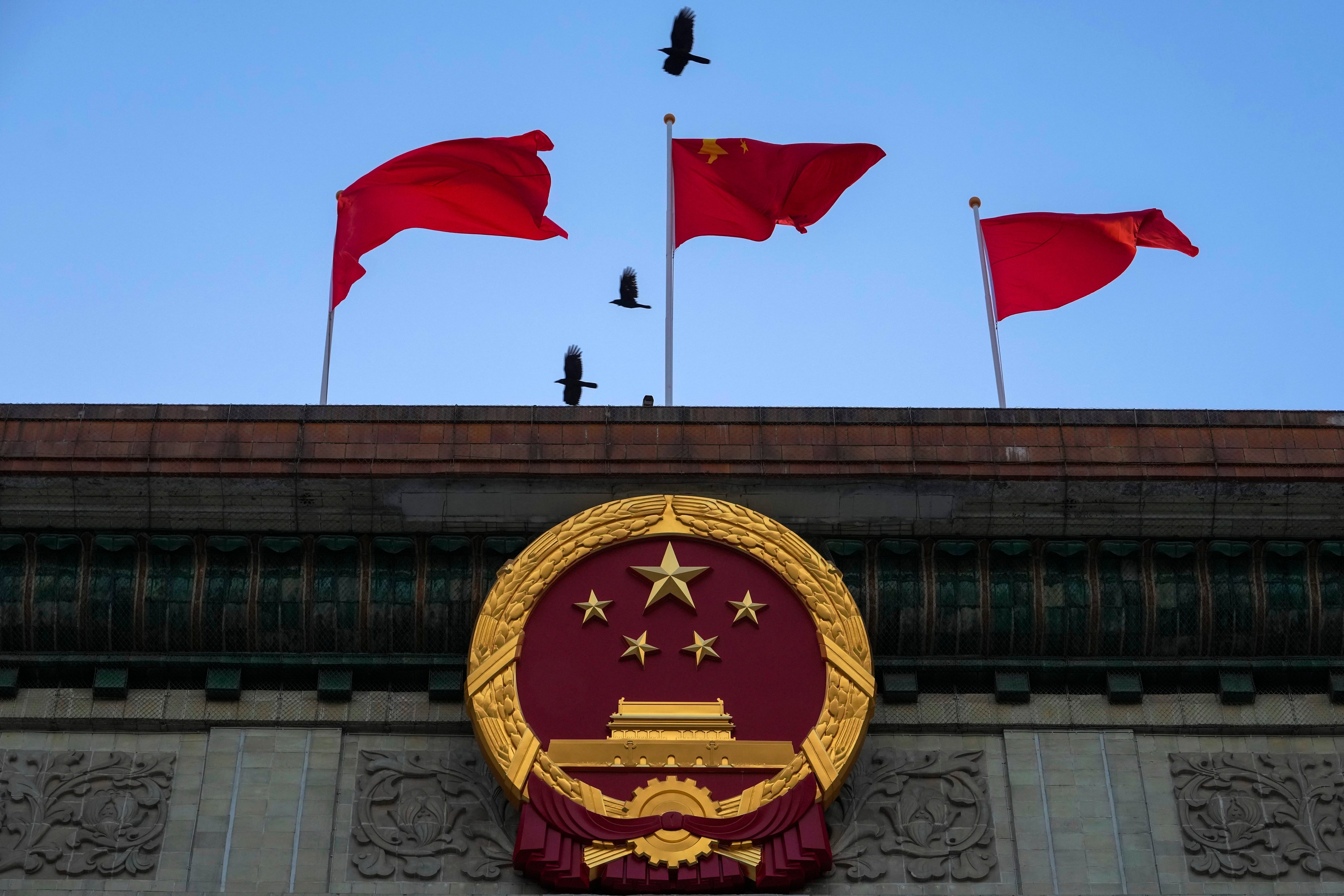 The Chinese national emblem and flags at the Great Hall of the People in Beijing. Recent weeks have signalled that Beijing has prioritised economic recovery and is willing to take more than incremental measures to achieve that goal. Photo: AP