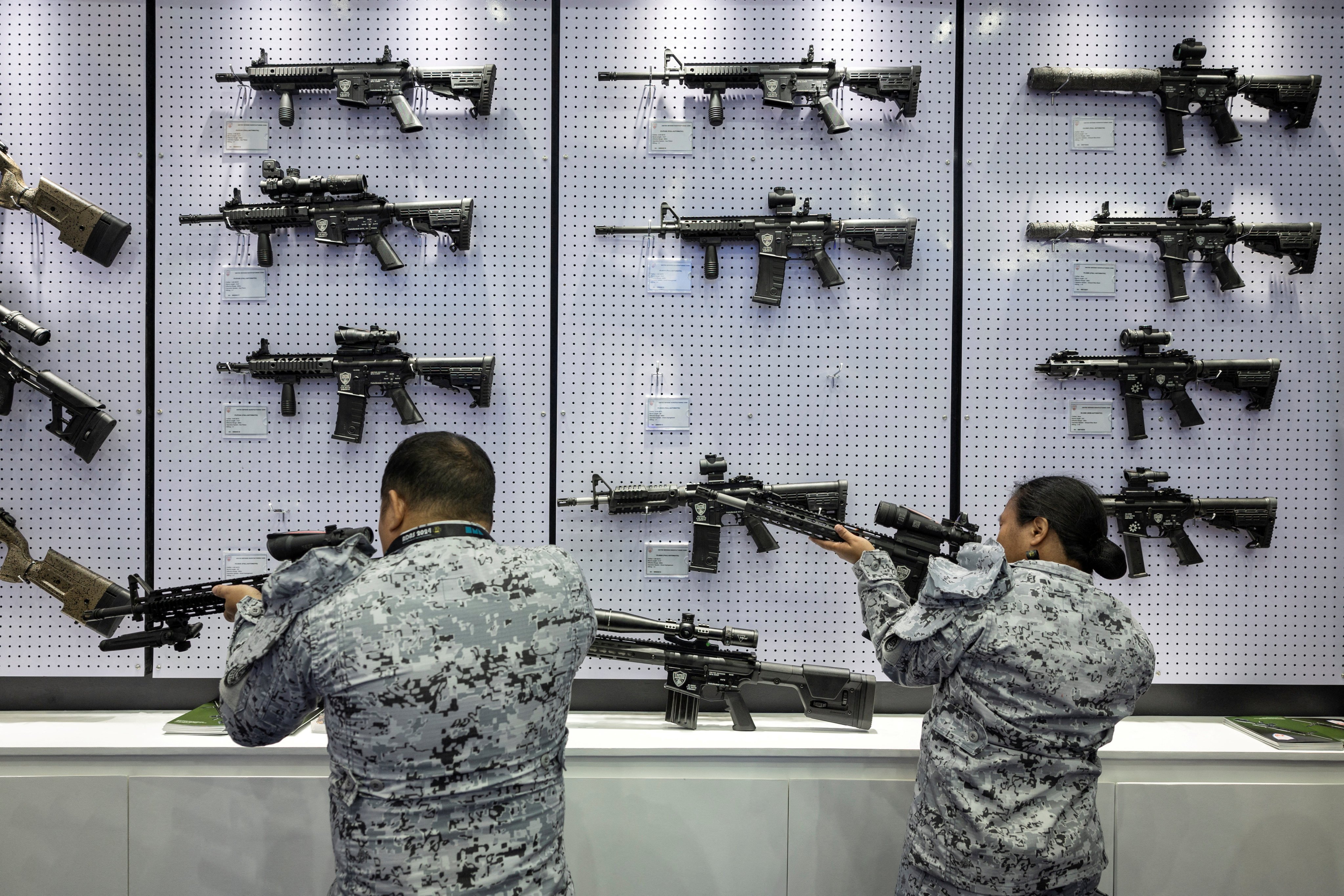 Philippine navy personnel check rifles on display at an arms fair in Pasay City, Metro Manila, last month. Photo: Reuters