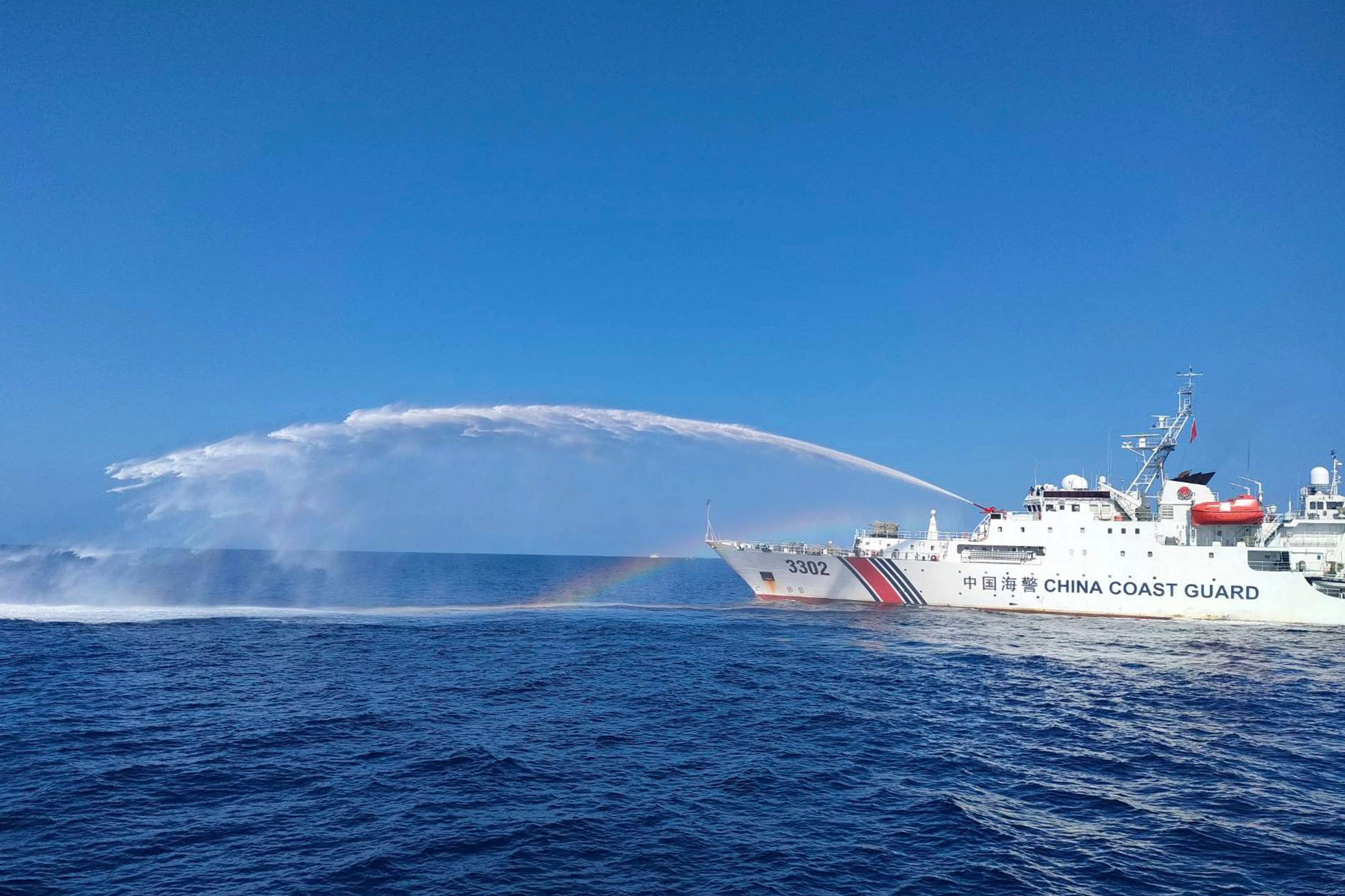 In this file photo, a China Coast Guard ship fires a water cannon towards a Philippine fisheries vessel as it approaches the Scarborough Shoal. Photo: Philippine coastguard via AP