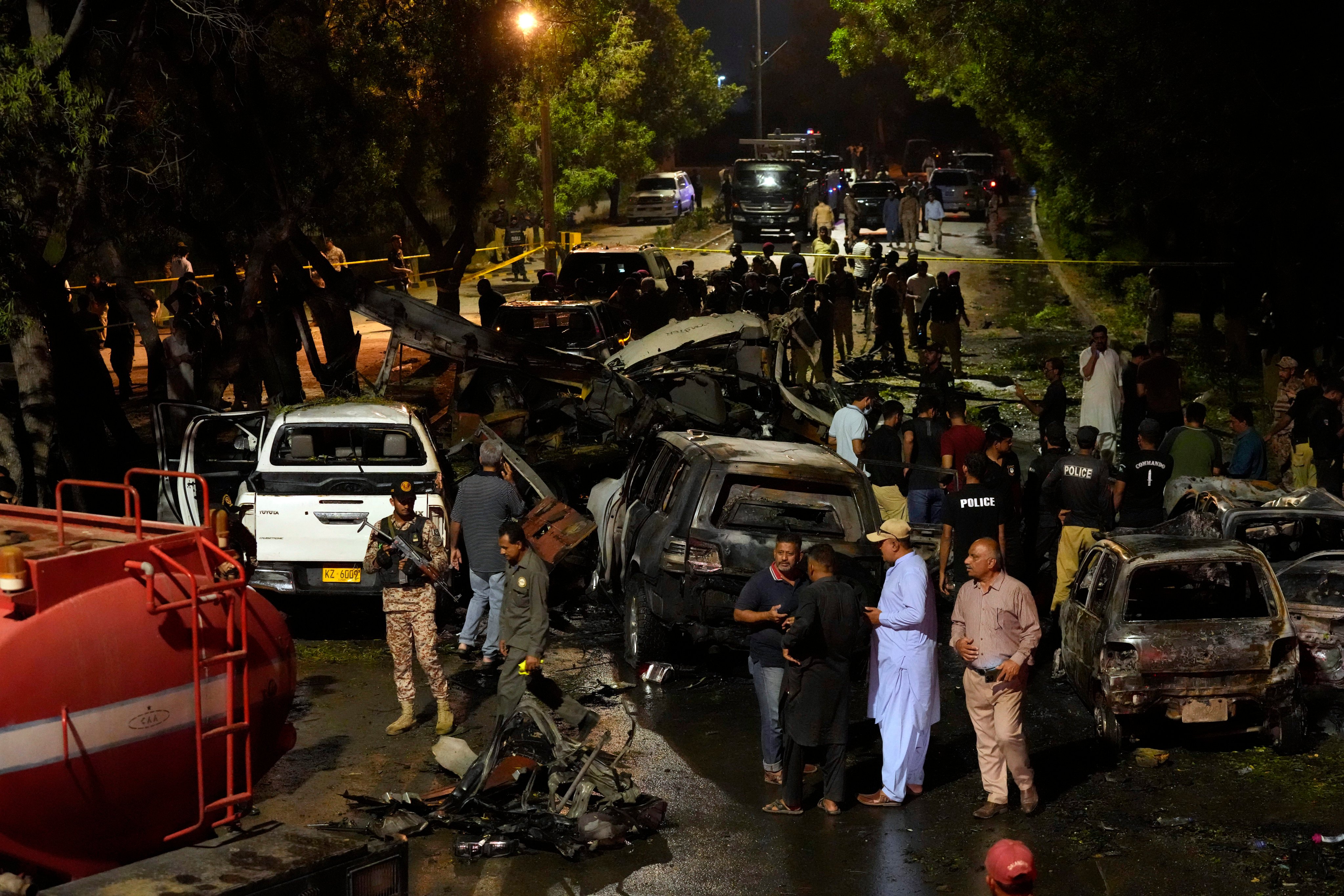 Security officials on Monday examine the site of a suicide attack that killed two Chinese nationals outside the international airport in Karachi, Pakistan. Photo: AP