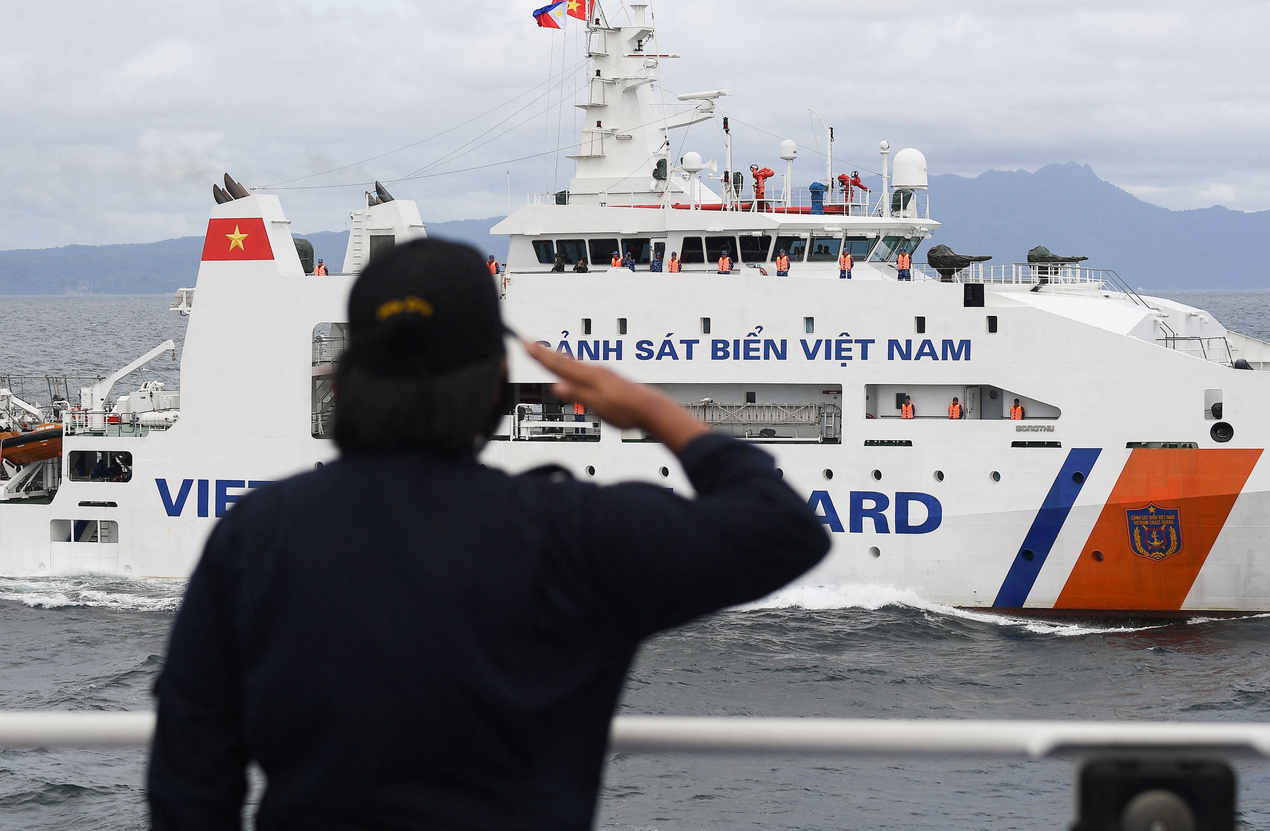 A member of the Philippine Coast Guard personnel salutes as a Vietnamese Coastguard ship during a joint maritime exercise in the disputed South China Sea on August 9. Photo: AFP