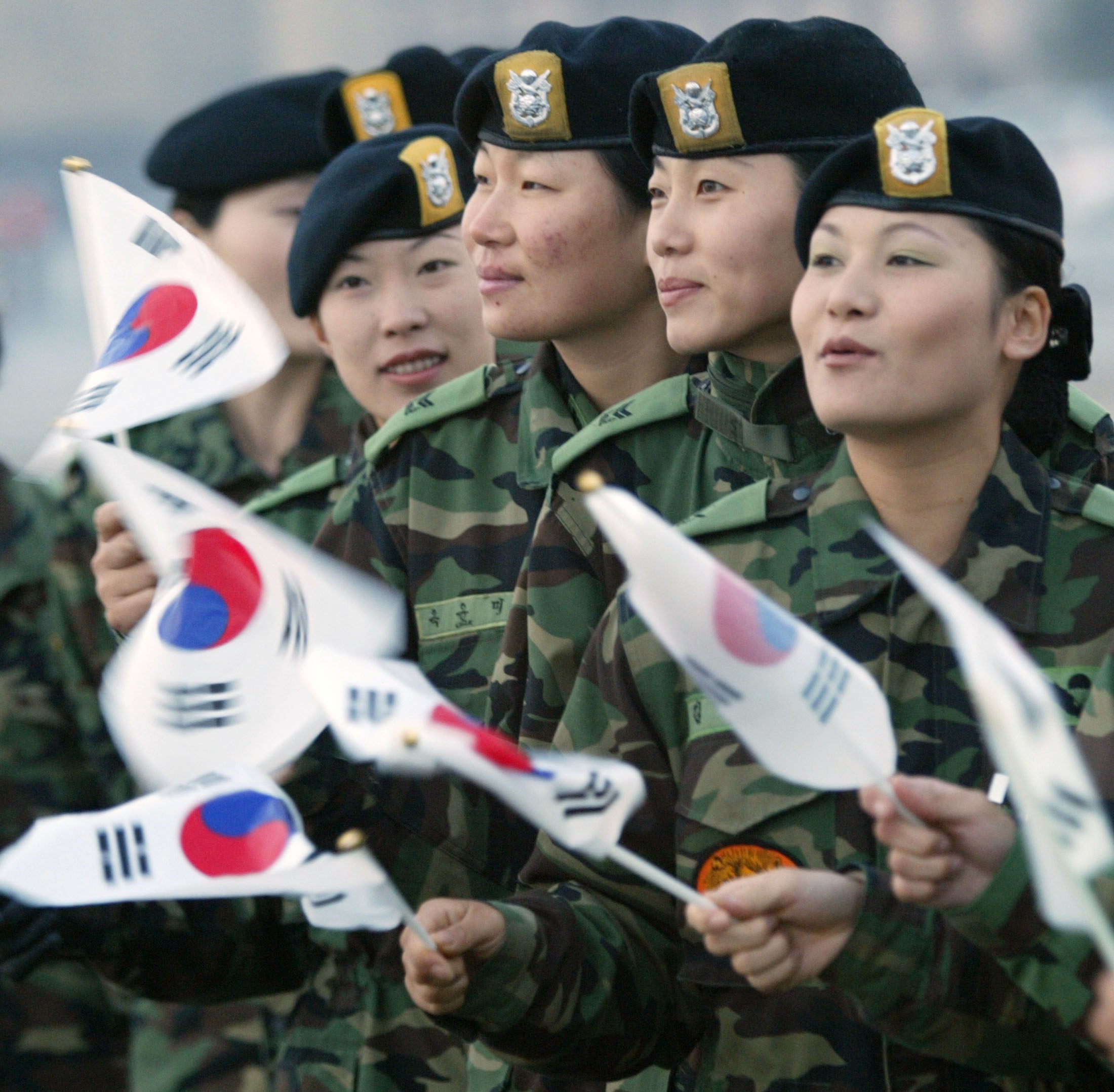 South Korean soldiers wave national flags to say goodbye as their colleagues depart for Iraq at Seoul military airport on October 22, 2003. Photo: Reuters