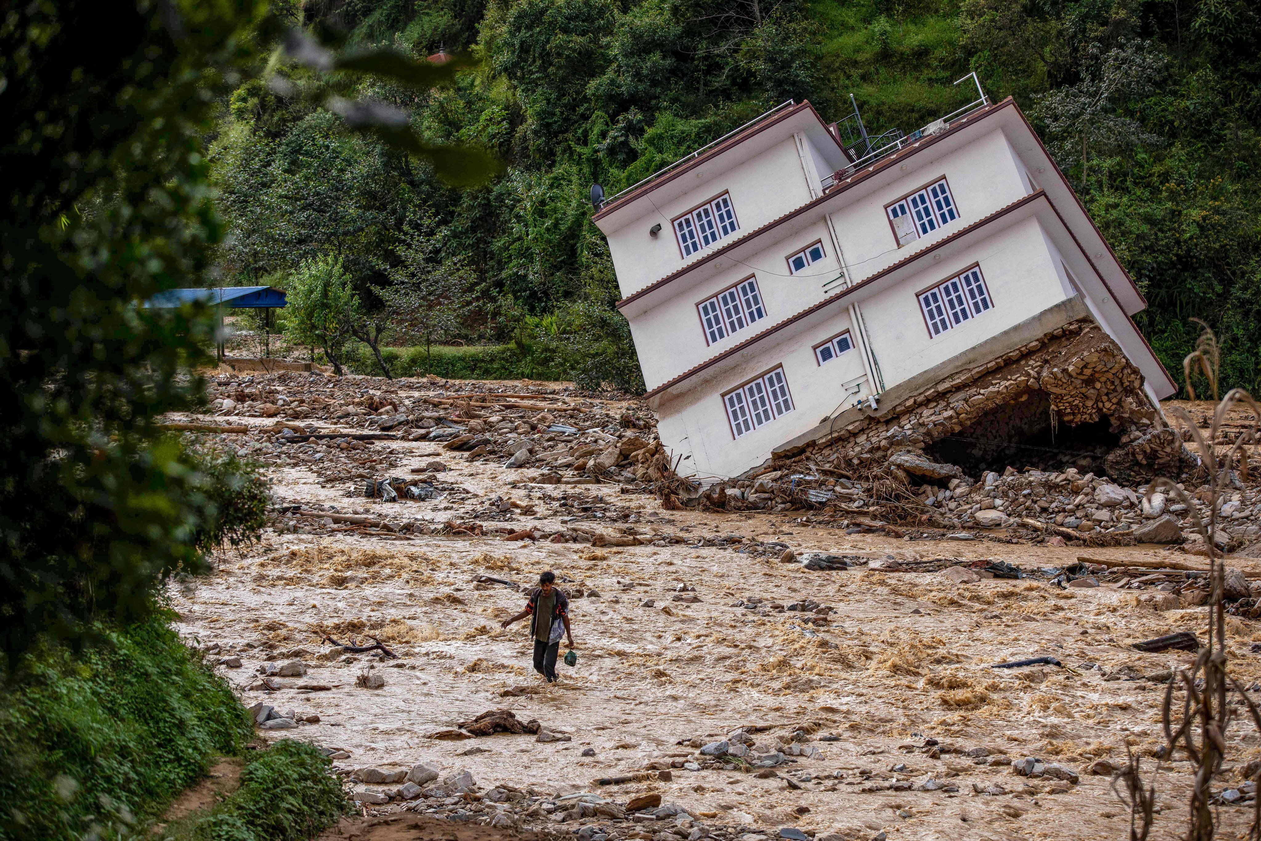 A man wades through the waters of monsoon flooding in Roshi village of Nepal’s Kavre district on September 30. Photo: AFP