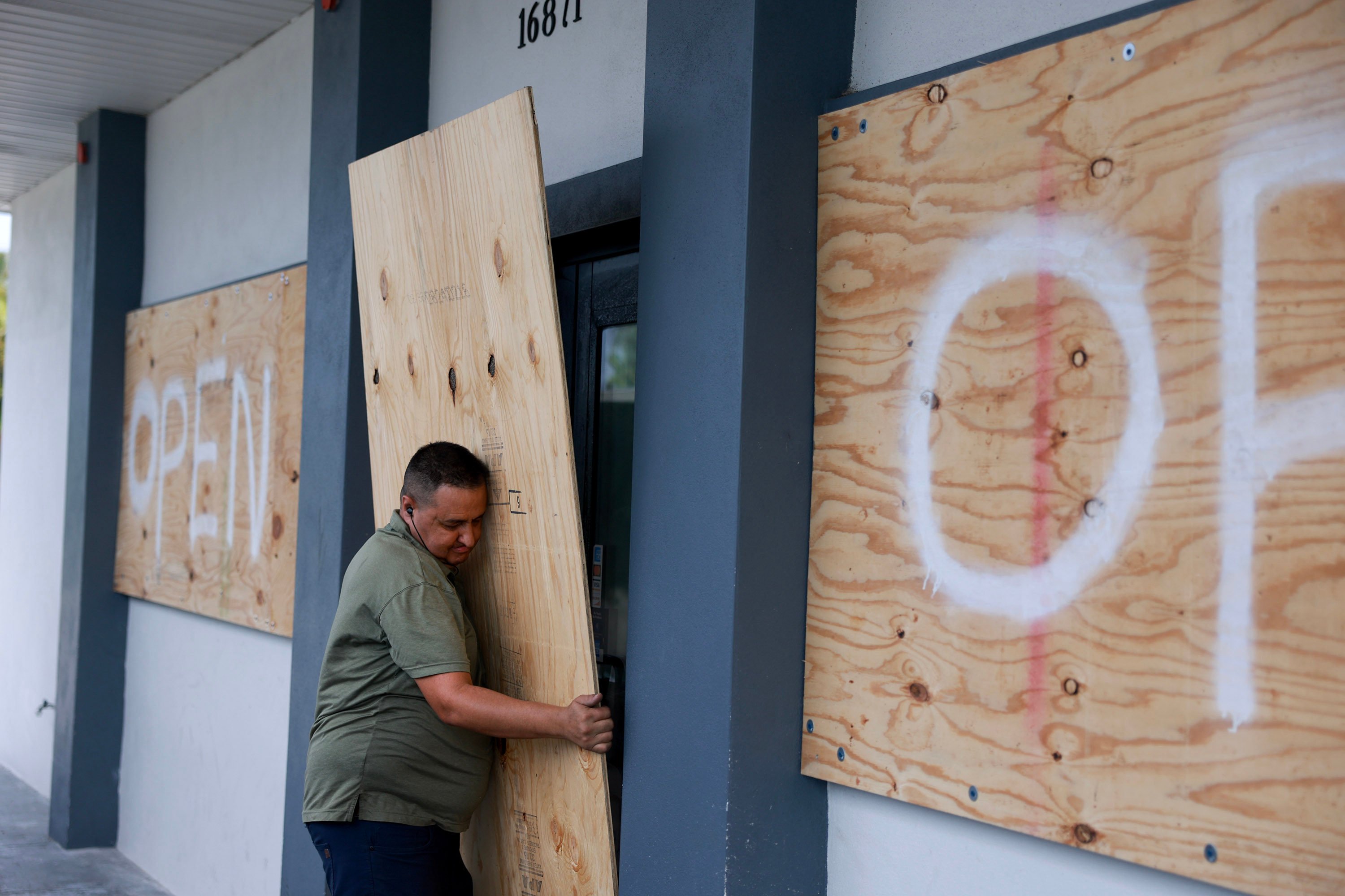 A man in Fort Myers places plywood over the windows of a business before Hurricane Milton’s arrival. Photo: TNS