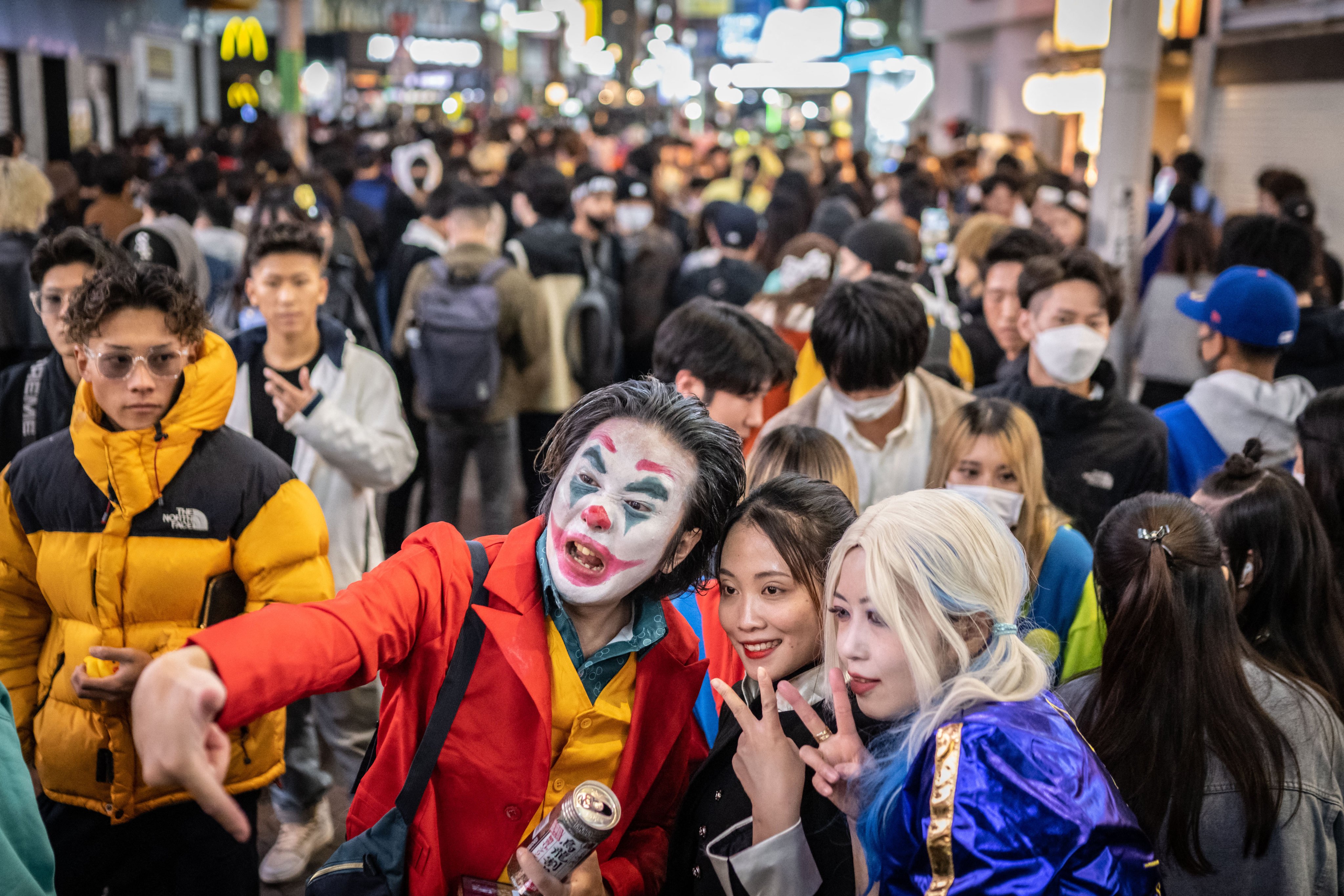 People wearing costumes pose for photographs in the Shibuya district of Tokyo at Halloween. Photo: AFP