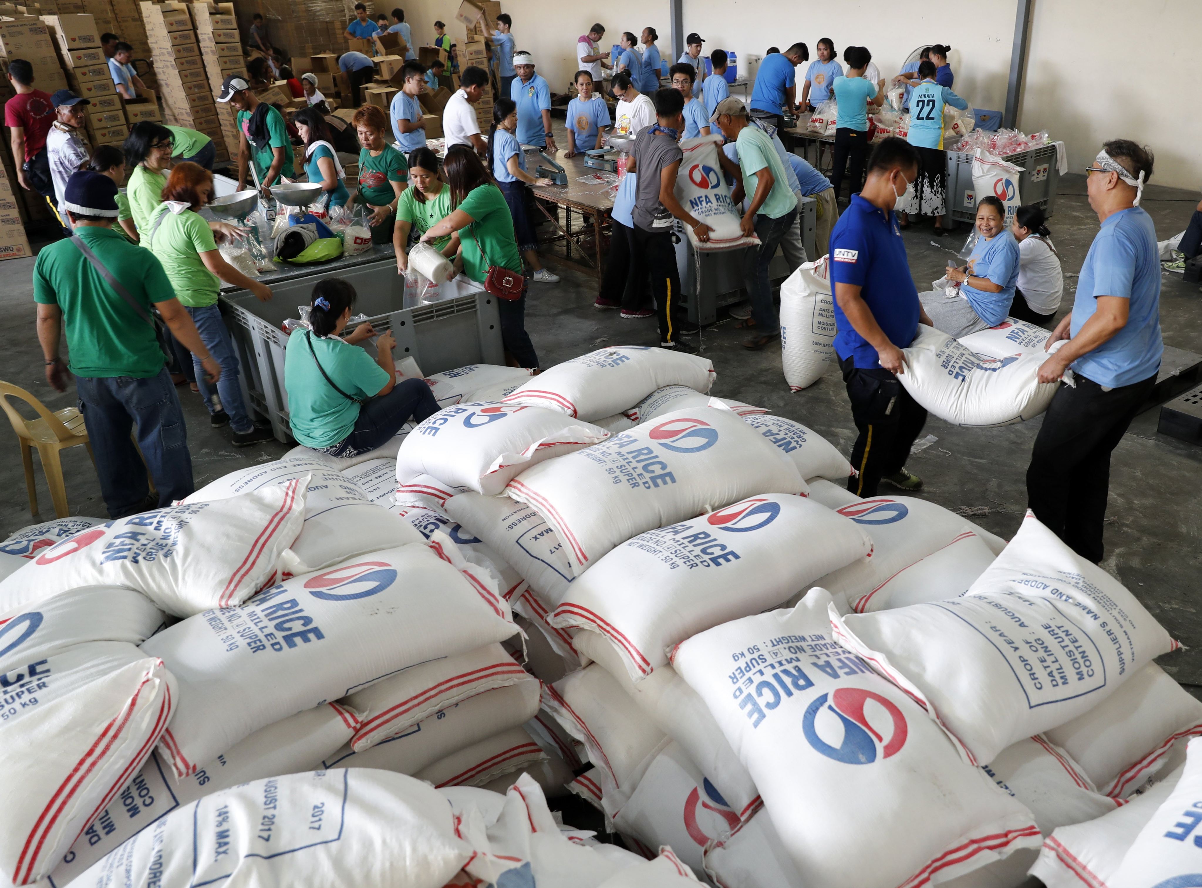 Filipino volunteers from Church of God International repack relief goods at a government storage facility in Pasay, the Philippines, in 2017. Photo: EPA-EFE