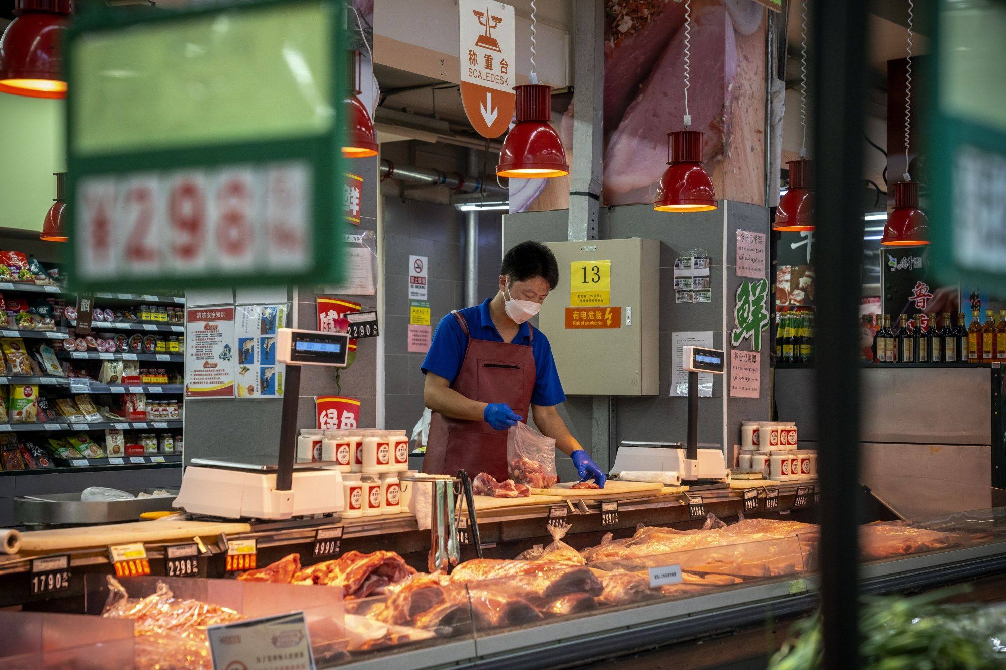 A vendor cuts meat at a supermarket in Beijing. Photo: Bloomberg