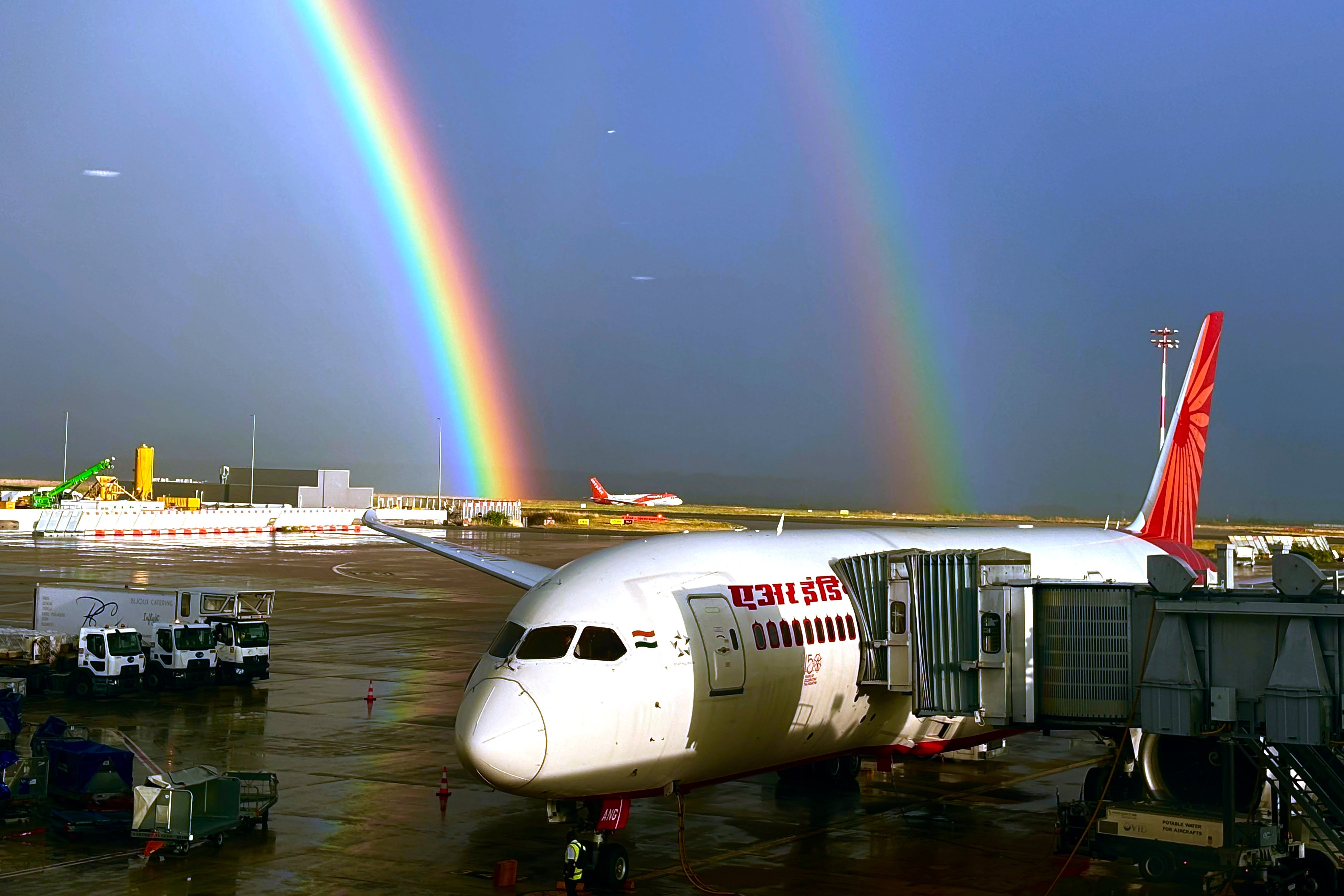 An Air India aircraft, owned by the Tata Group, is seen parked against a double rainbow formed over Charles de Gaulle Airport in Paris, France. Photo: AP