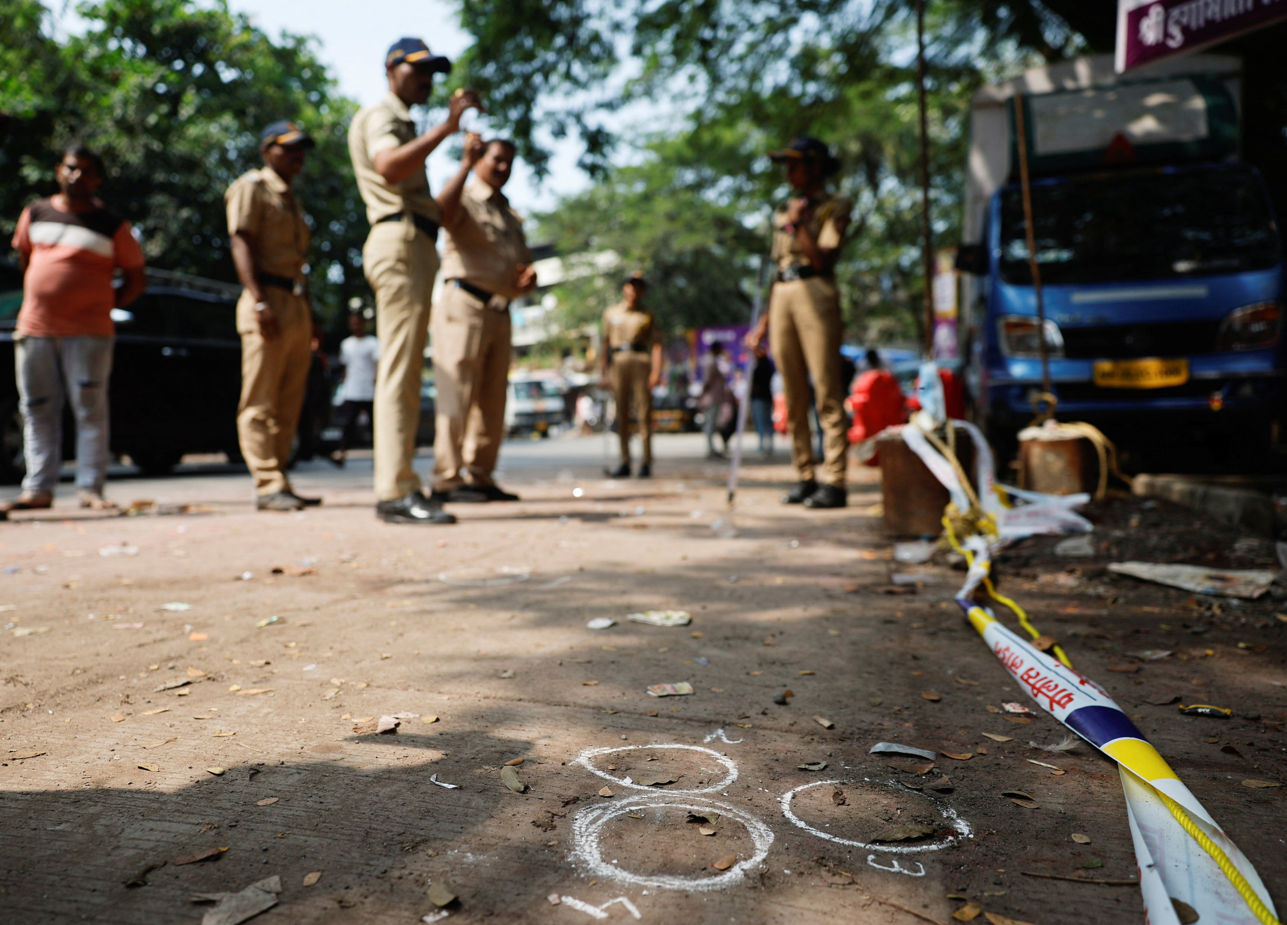 Police officers stand at the crime scene next to markings of the gunshots where Nationalist Congress Party (NCP) politician Baba Siddique was shot dead in Mumbai. Photo: Reuters