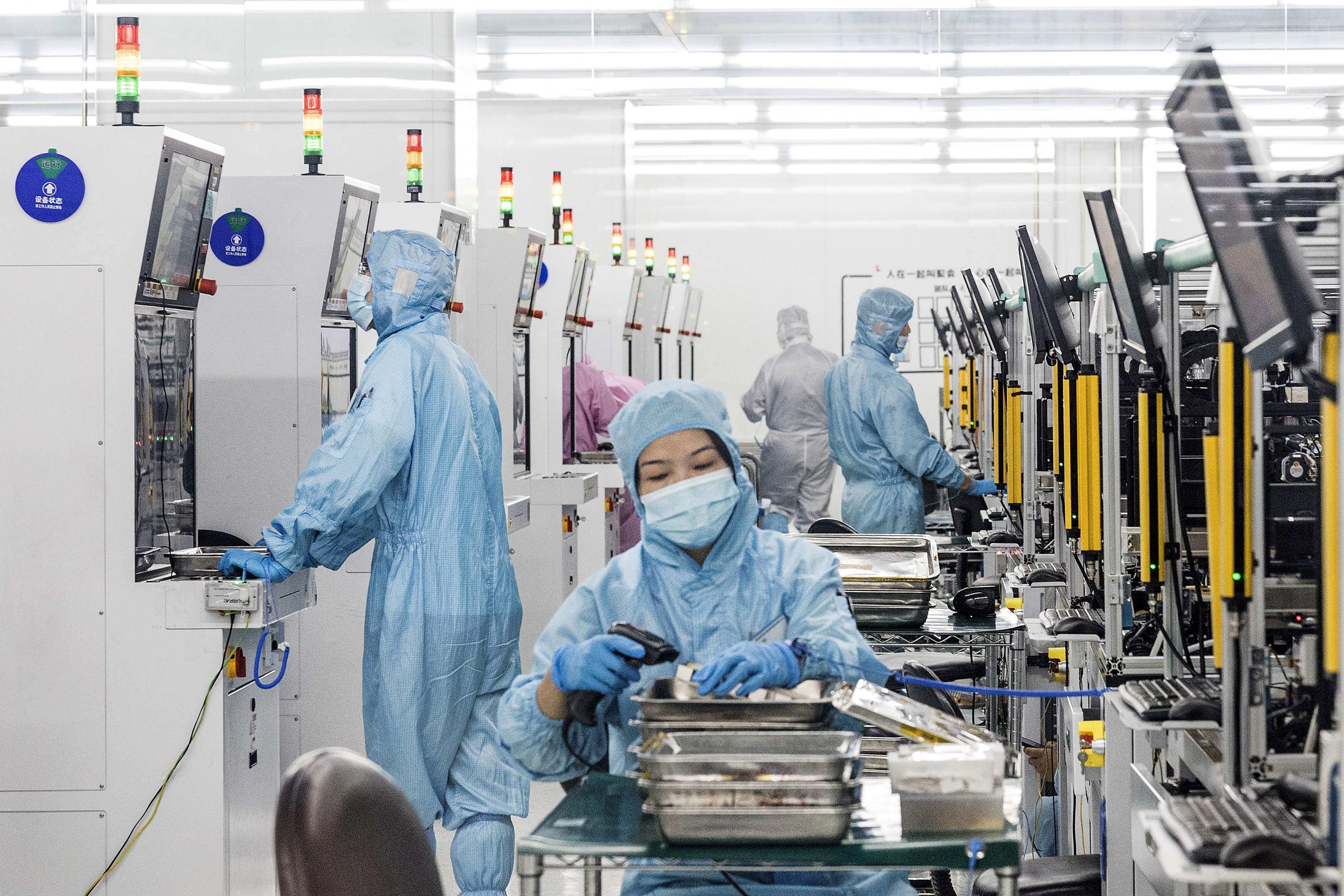 Technicians produce fiber lasers at a factory in Huangshi, Hubei province, on August 3, 2023. Photo: AFP