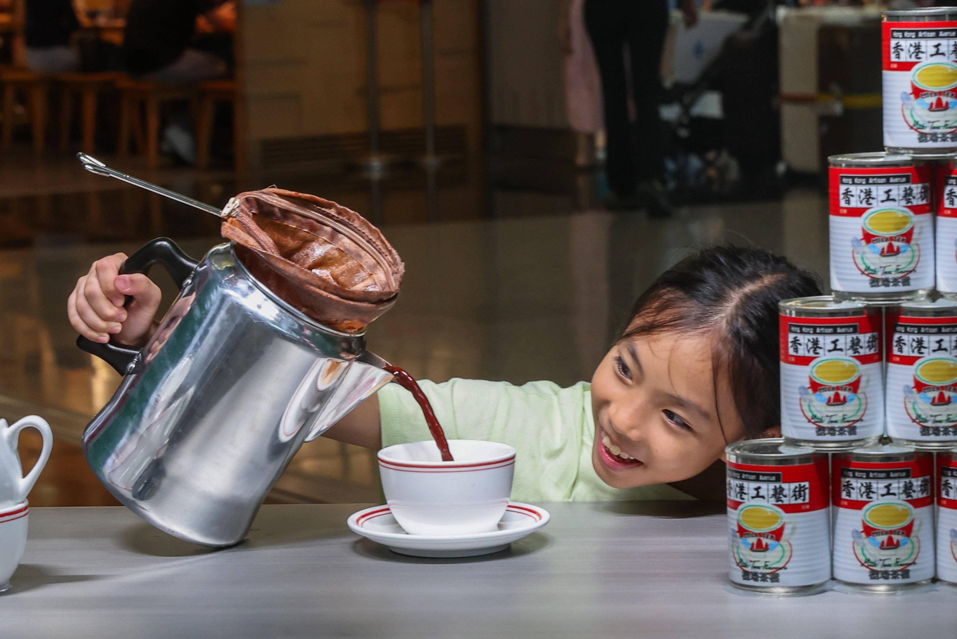 A girl poses with Milk Tea Flavours installation at HKIA Arts & Culture Festival in Hong Kong Airport. Photo: Edmond So