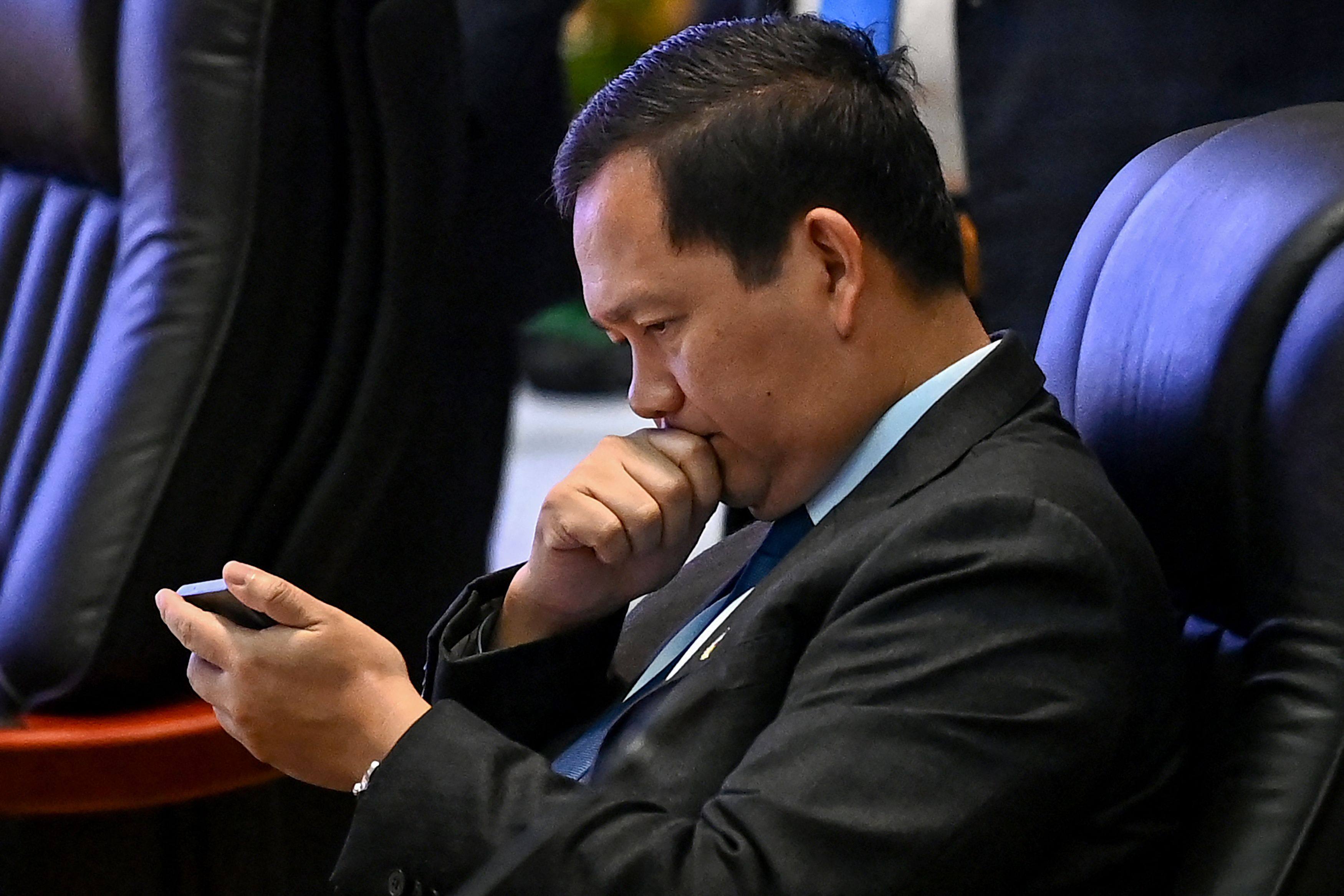 Cambodia’s Prime Minister Hun Manet looks at a phone at the Asean summit in Vientiane on Friday. Photo: AFP