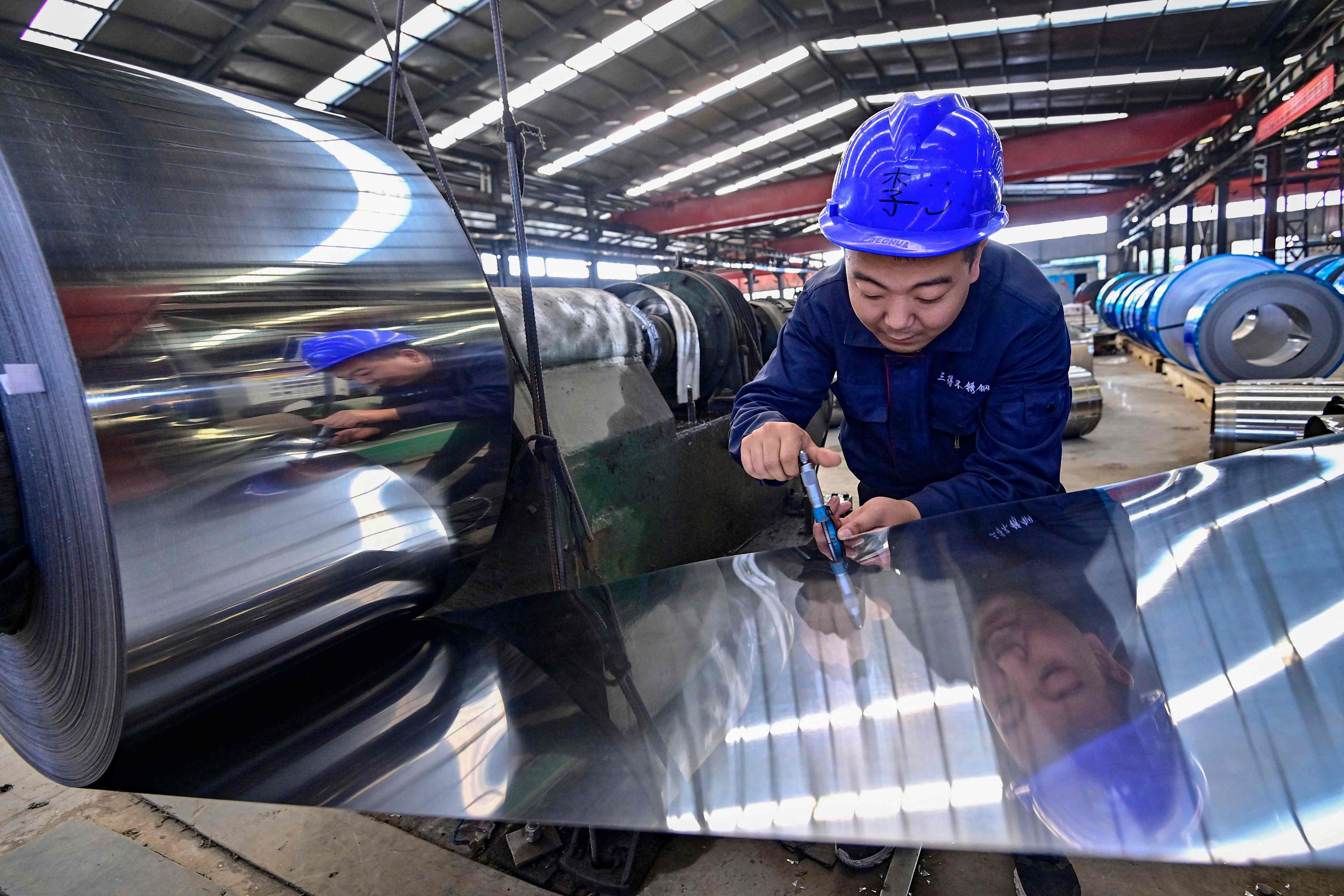 An employee works at a factory producing stainless steel materials in Qingzhou, in eastern Shandong province, on October 13. Photo: AFP