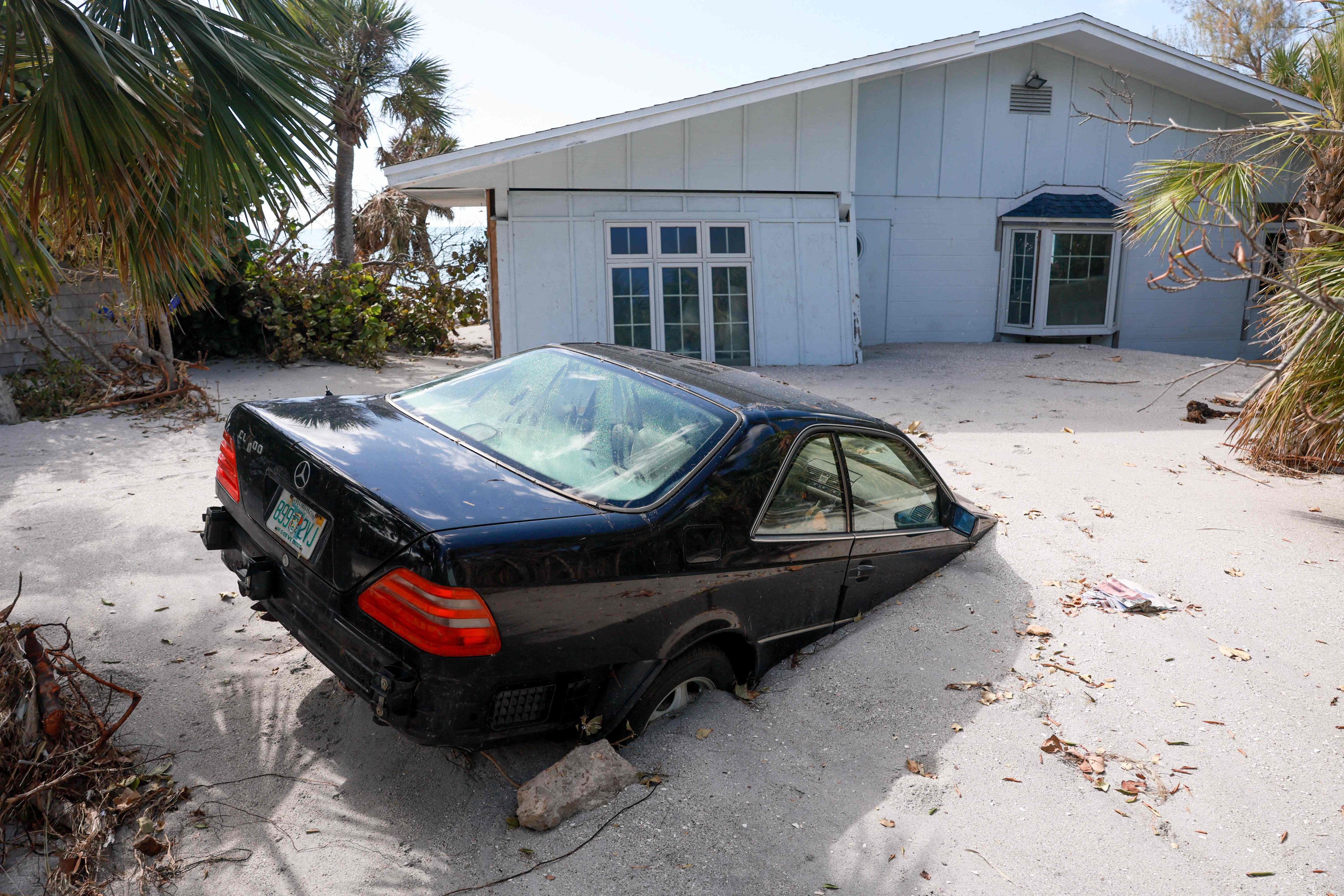 A vehicle sits stuck in beach sand in Manasota Key, Florida, on October 13 after Hurricane Milton barelled into the state. Photo: Getty Images