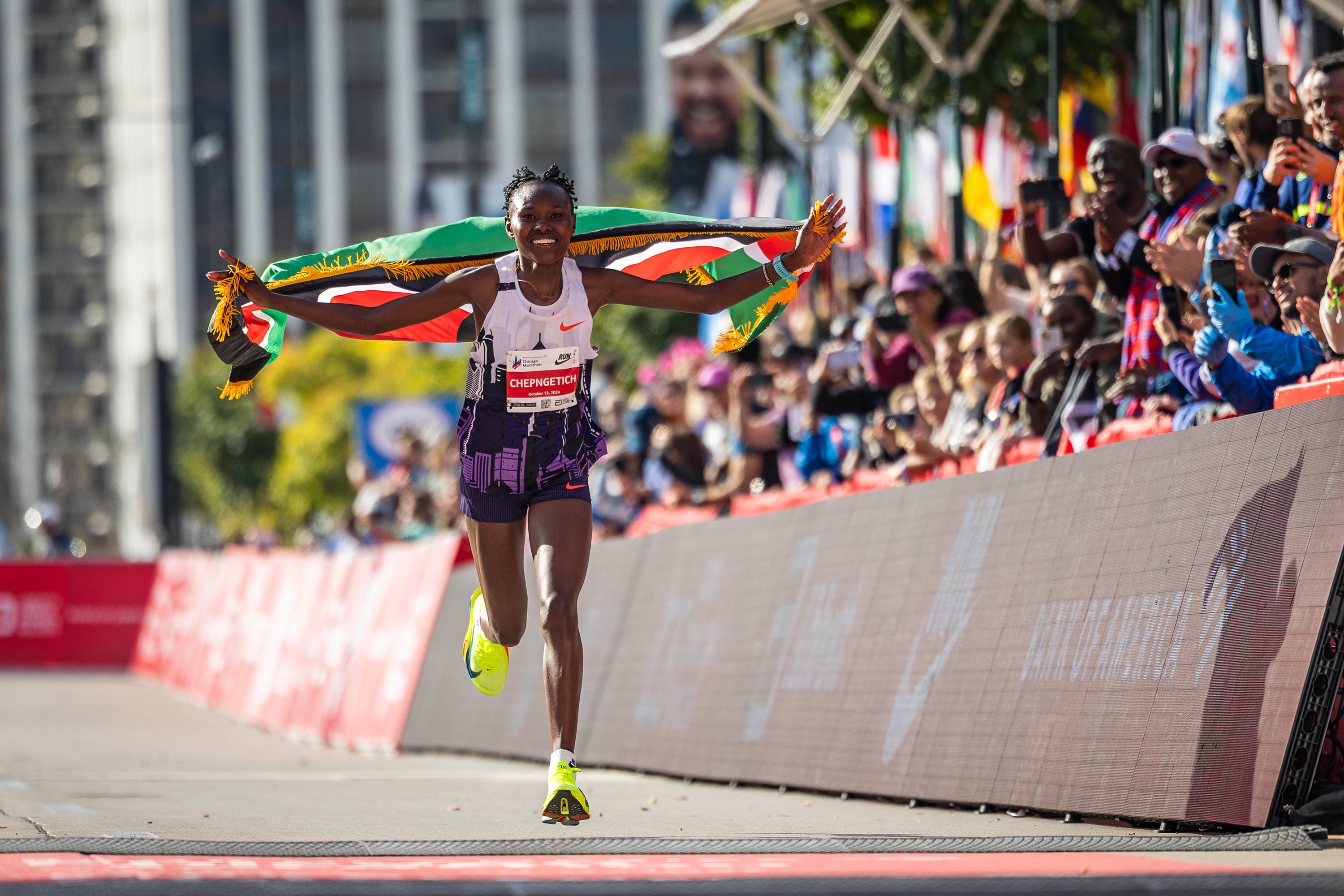 Ruth Chepngetich runs with the Kenyan flag after crossing the finish line at the Chicago Marathon. Photo: TNS