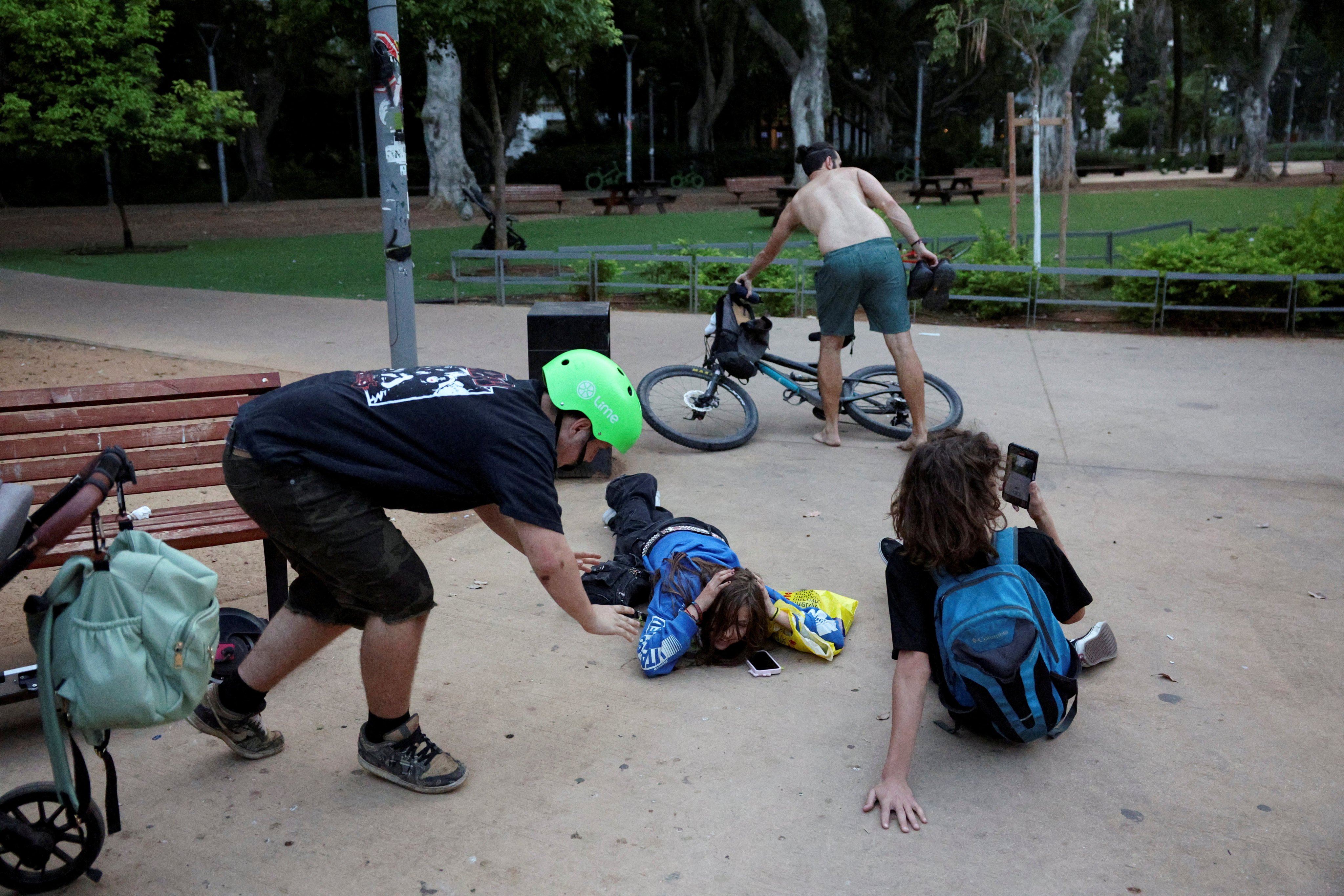 People take cover in Tel Aviv, Israel as sirens sound in response to projectiles fired from Lebanon. Photo: Reuters