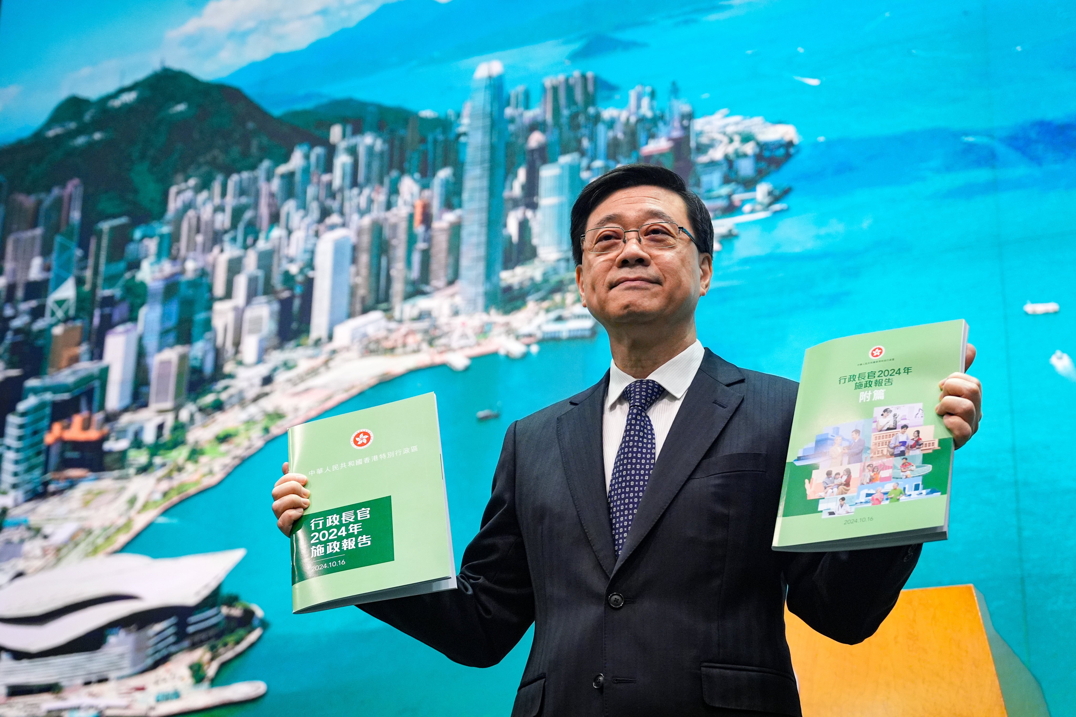 Hong Kong Chief Executive John Lee holds up copies of his third policy address, which he is set to deliver on Wednesday. Photo: Eugene Lee