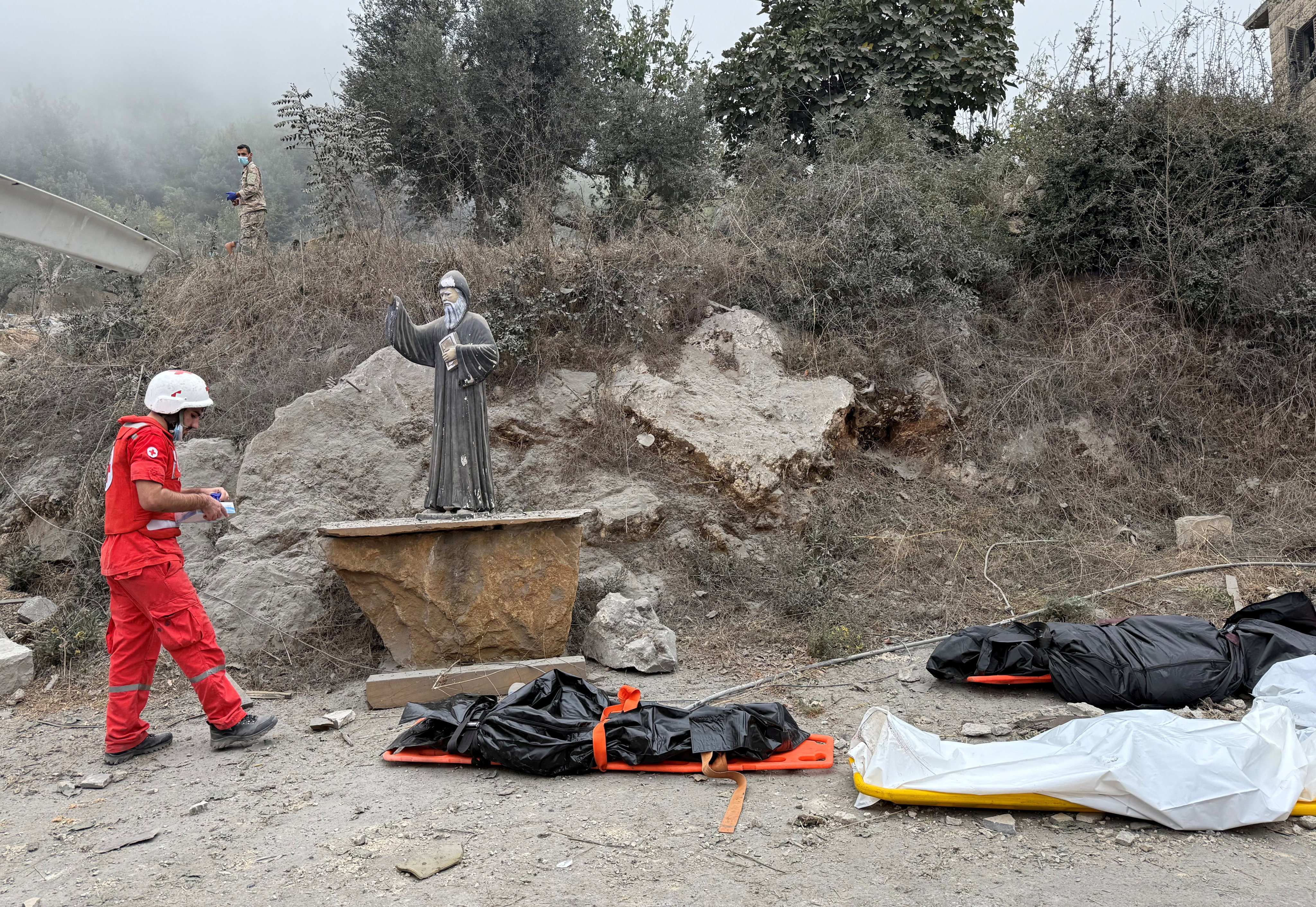 A member of the Lebanese Red Cross stands near casualties in bodybags at a site damaged by an Israeli strike in the Christian-majority region of Aitou in north Lebanon on Monday. Photo: Reuters