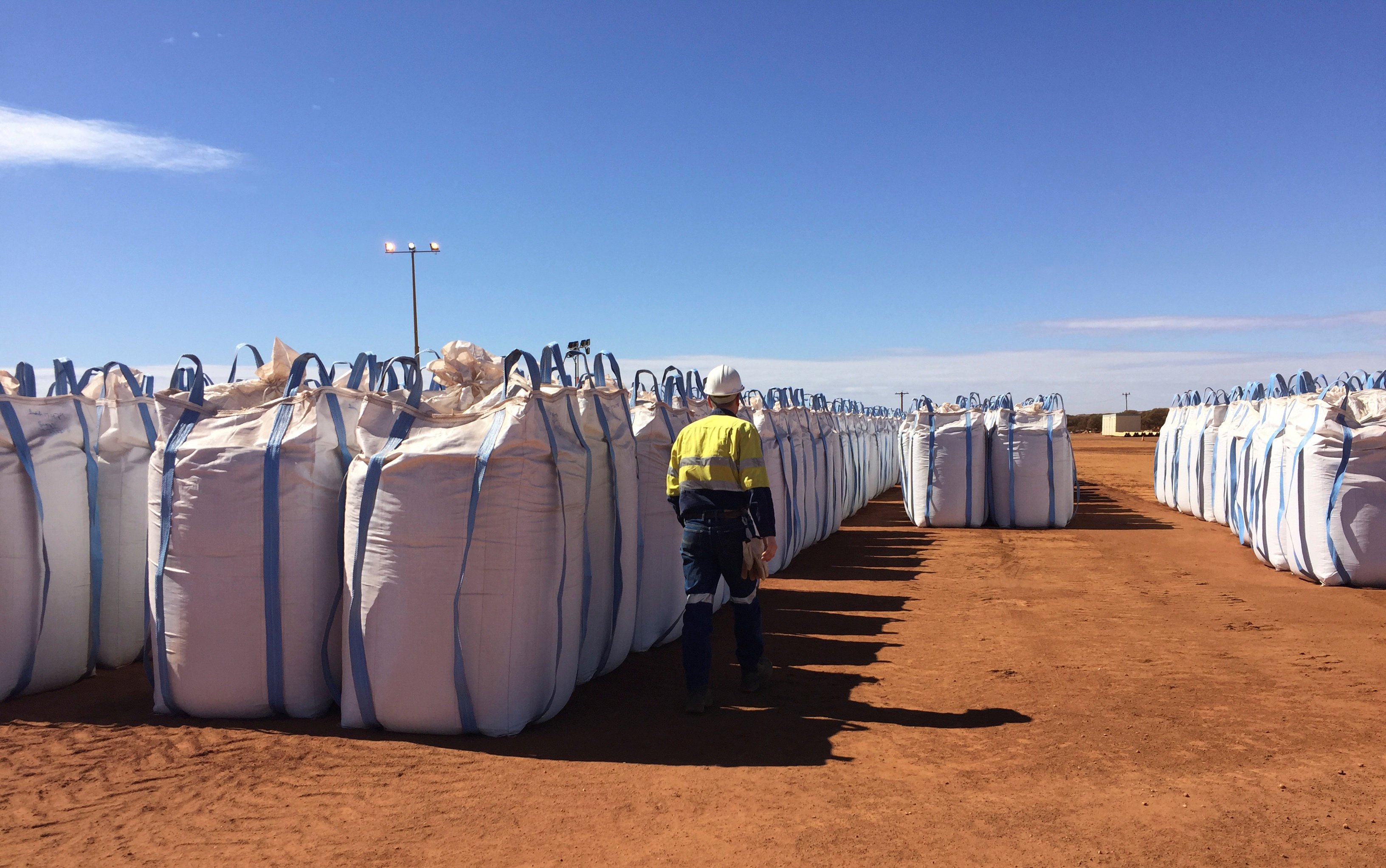 A mining worker walks past sacks of rare earth concentrate waiting to be shipped to Malaysia, at Mount Weld, northeast of Perth, Australia. Photo: Reuters