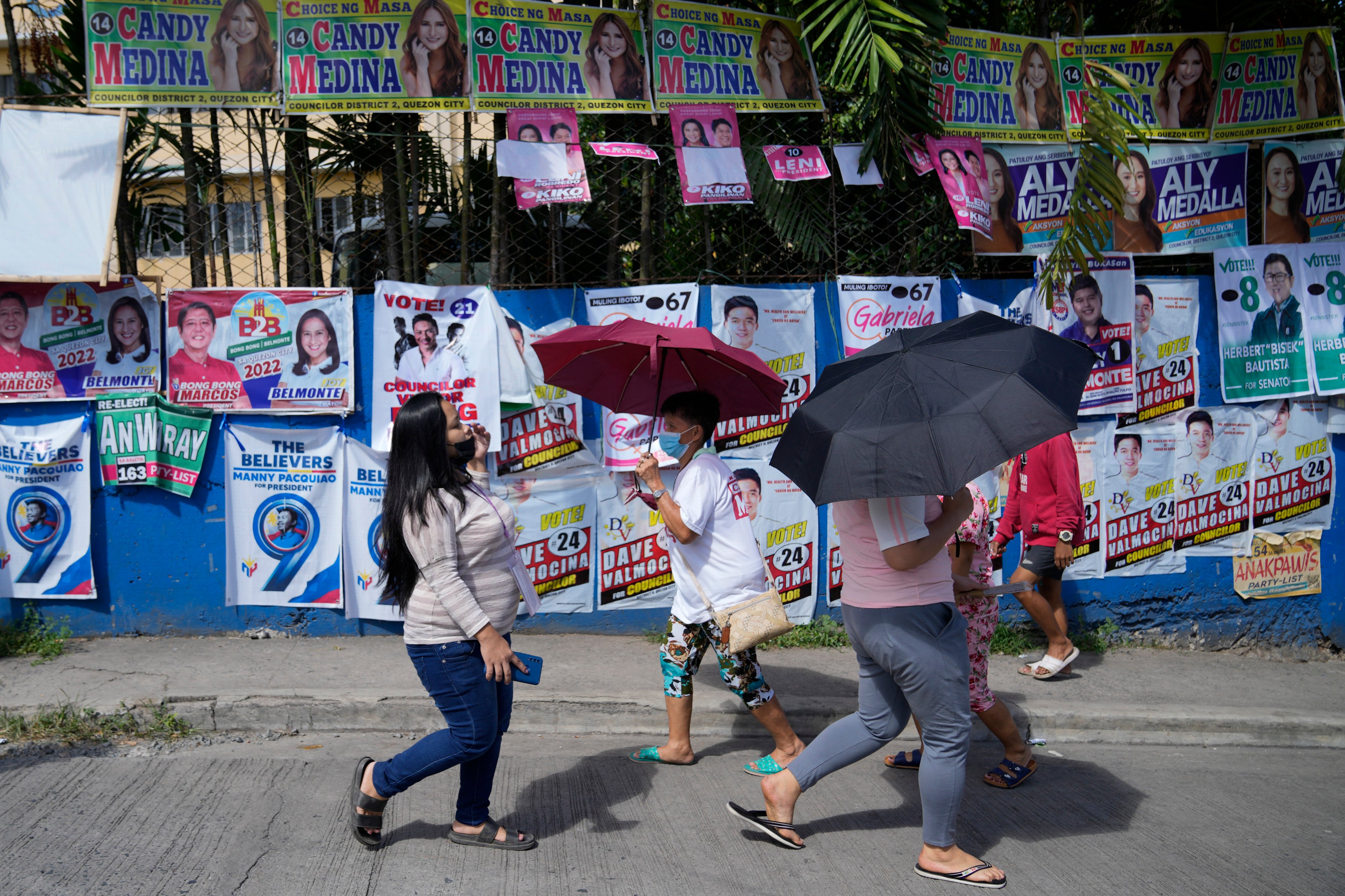 Voters pass by campaign posters outside a polling centre in Quezon City in 2022. More than 66 million registered Filipinos will cast their votes for over 18,280 candidates vying for posts across the country during midterm elections next May. Photo: AP