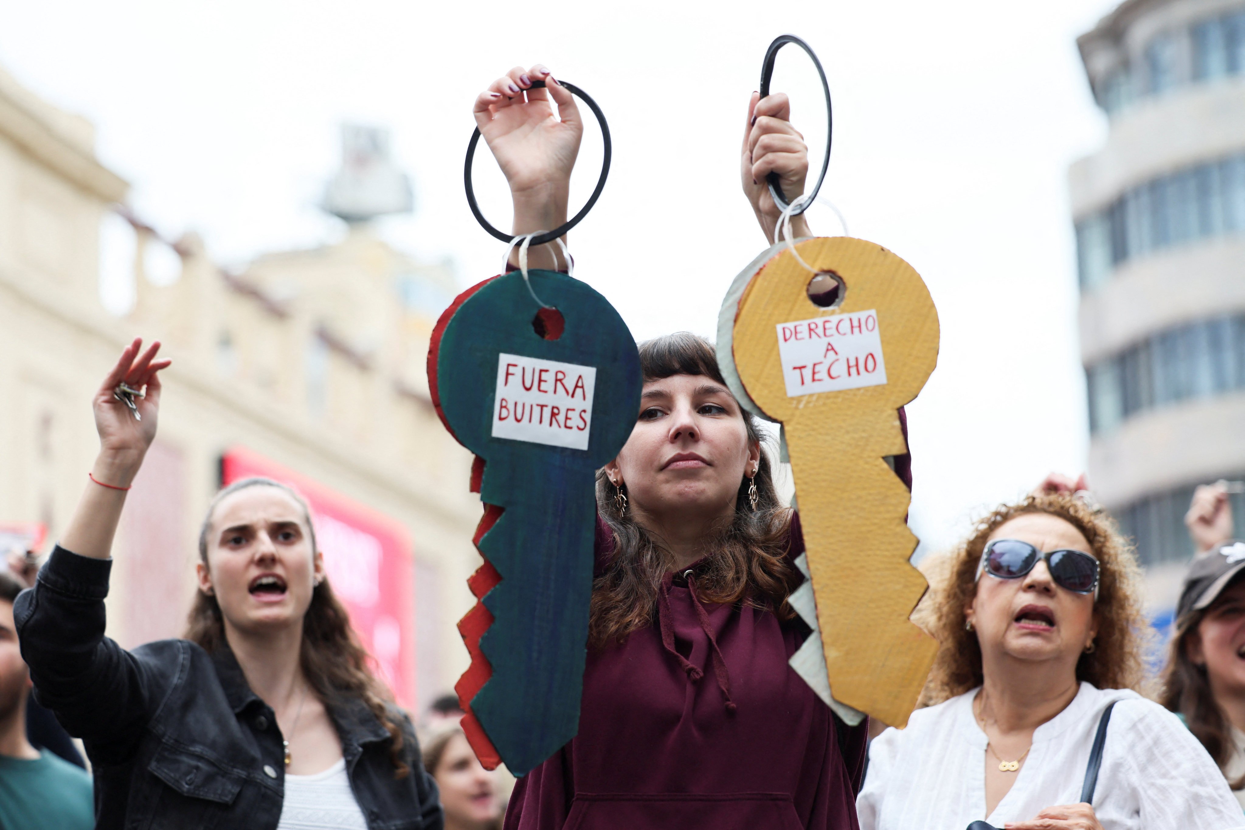 A woman holds cardboard keys at a protest against rising house prices in Madrid. Photo: Reuters