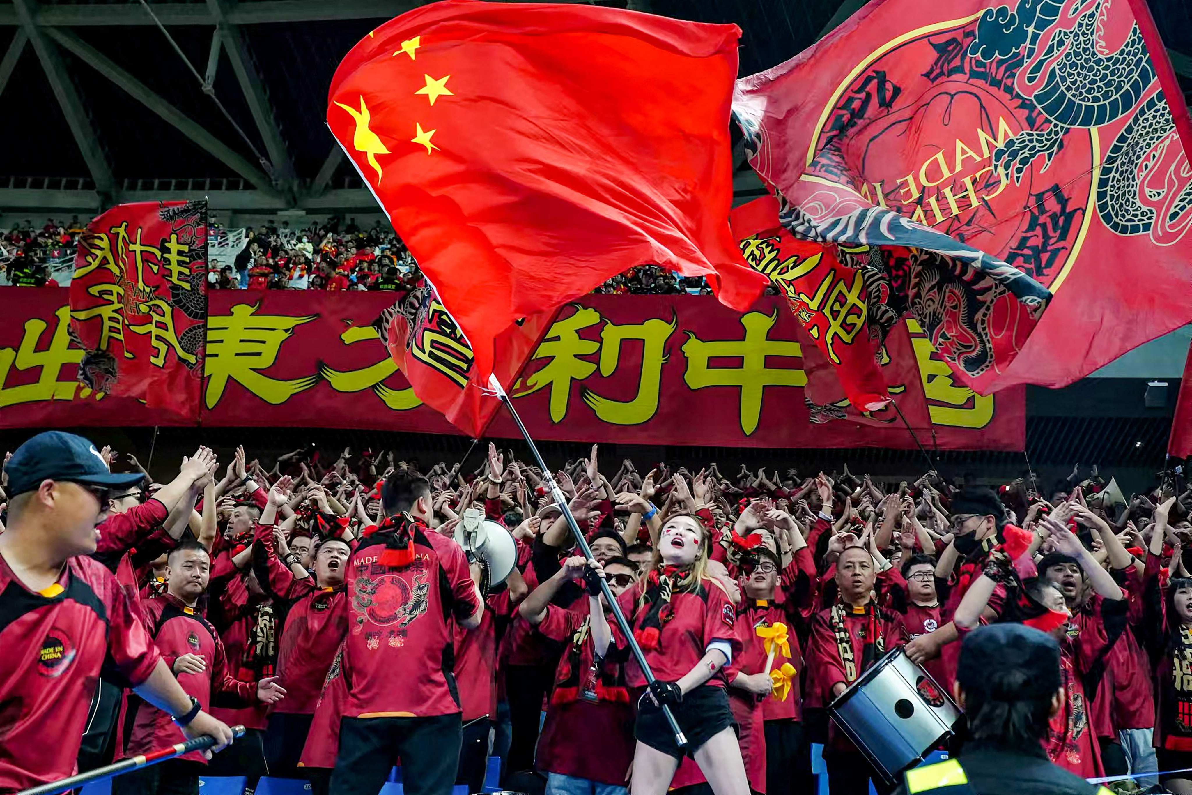 A fan waves China’s national flag to celebrate their team’s win against Indonesia at the 2026 FIFA World Cup Asian qualification match in Qingdao on Tuesday. Photo: AFP