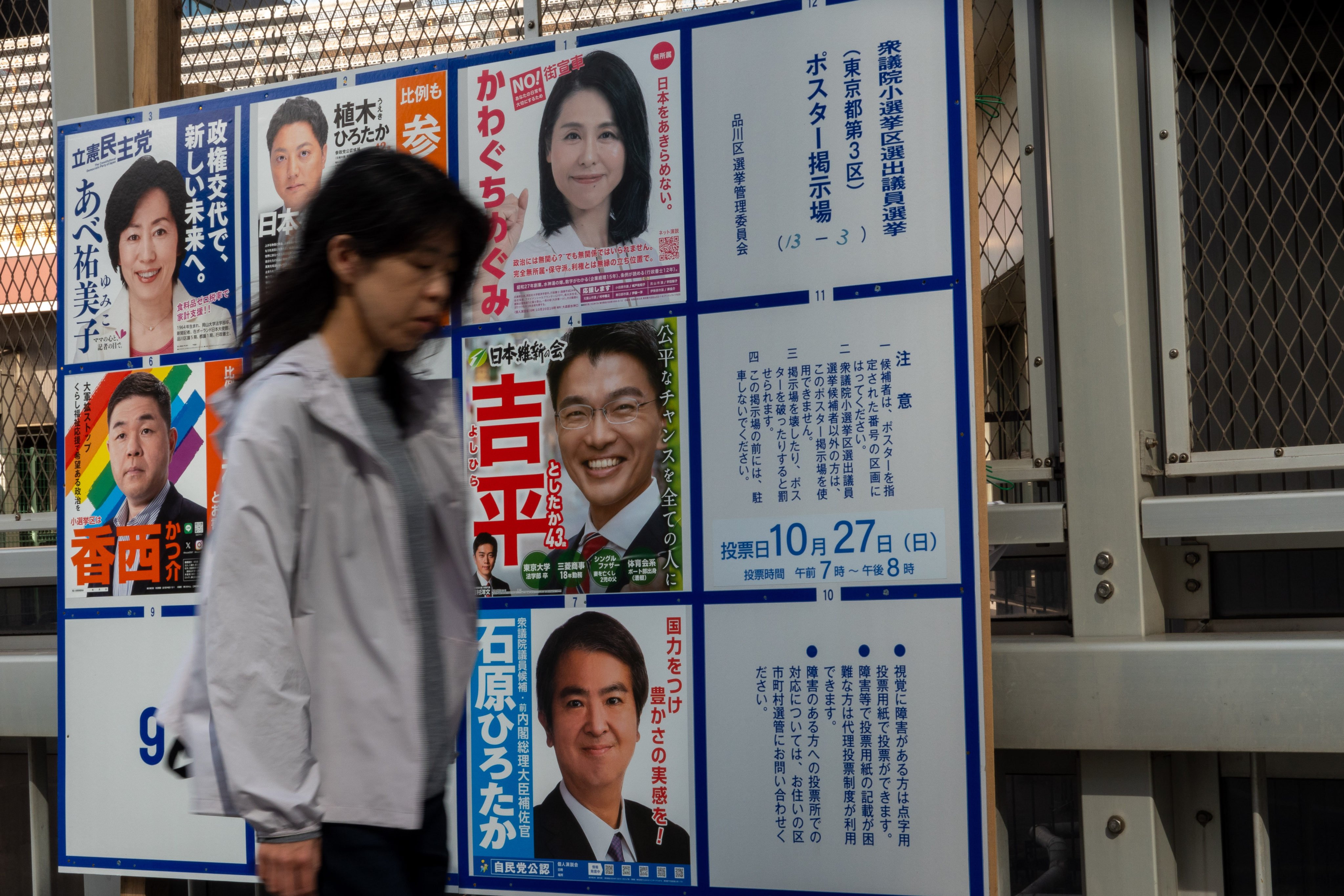 A woman walks past a billboard for the election campaign in Tokyo. A record number of women are running in the election but they still account for less than a quarter of candidates. Photo: Xinhua