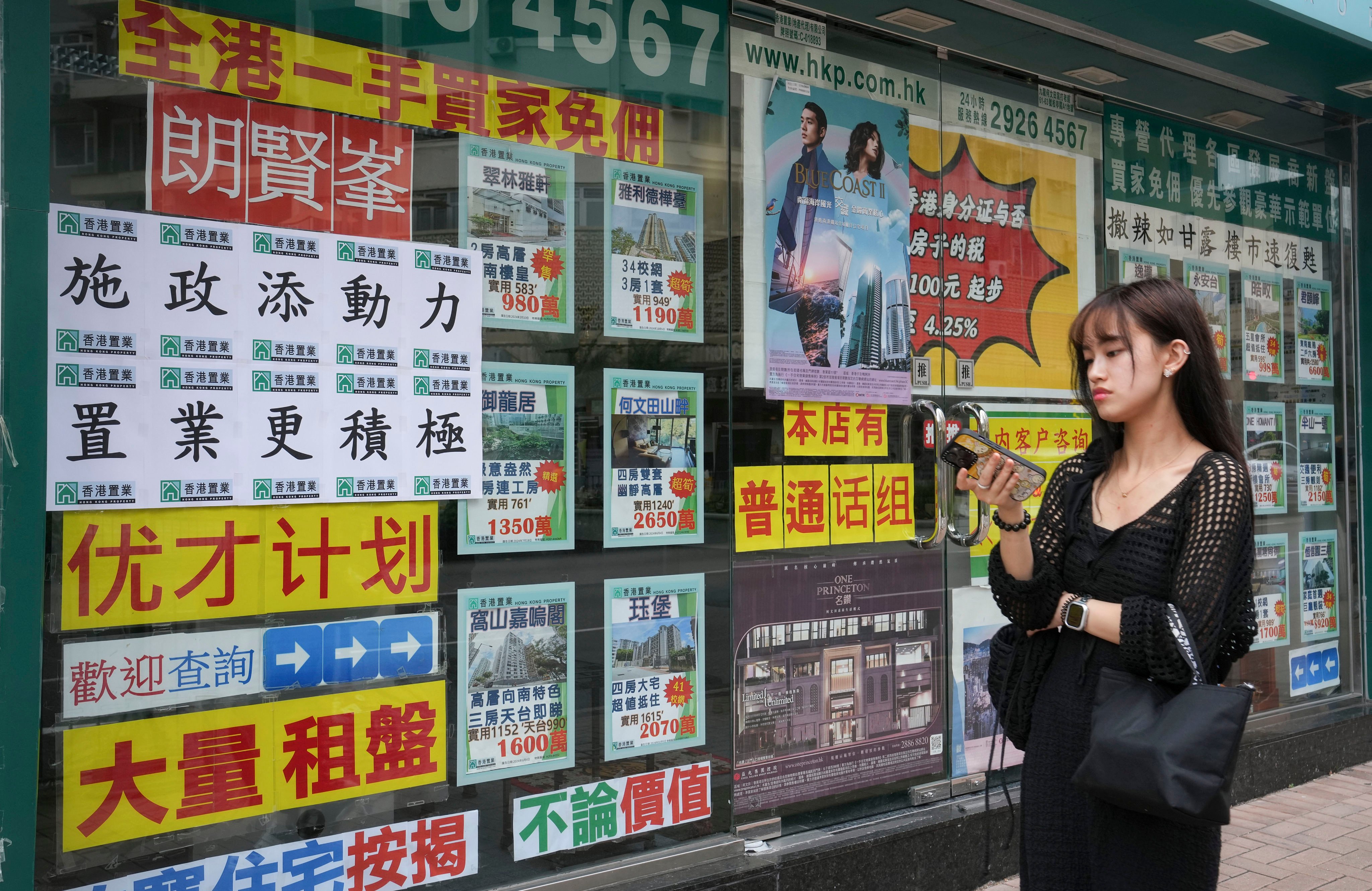 A slogan encouraging property purchases based on the latest policy address is posted at a real estate agency in Mong Kok. Photo: Elson Li