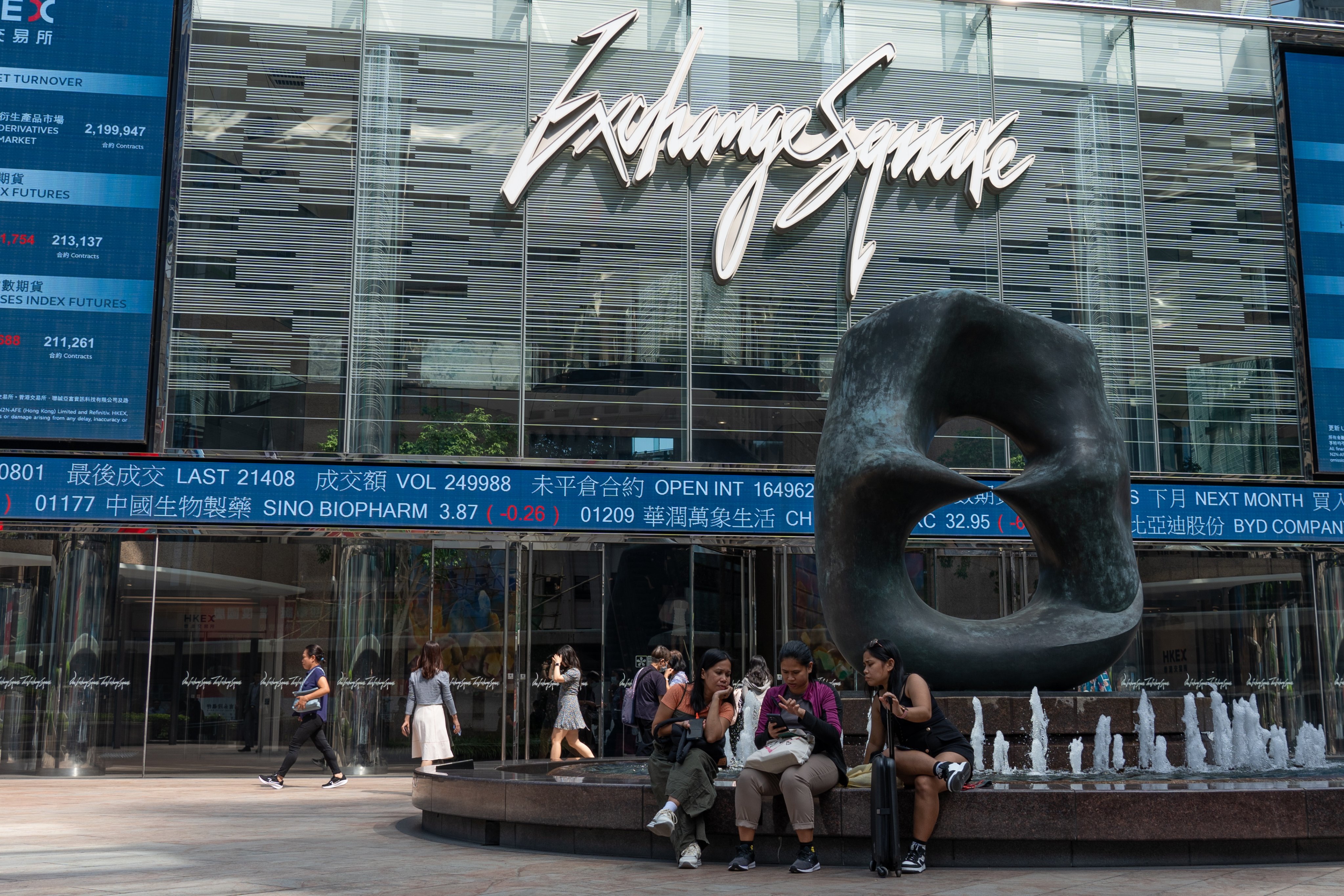 People sit in front of Exchange Square, the building housing the Hong Kong stock market, on October 8, 2024. Photo: EPA-EFE