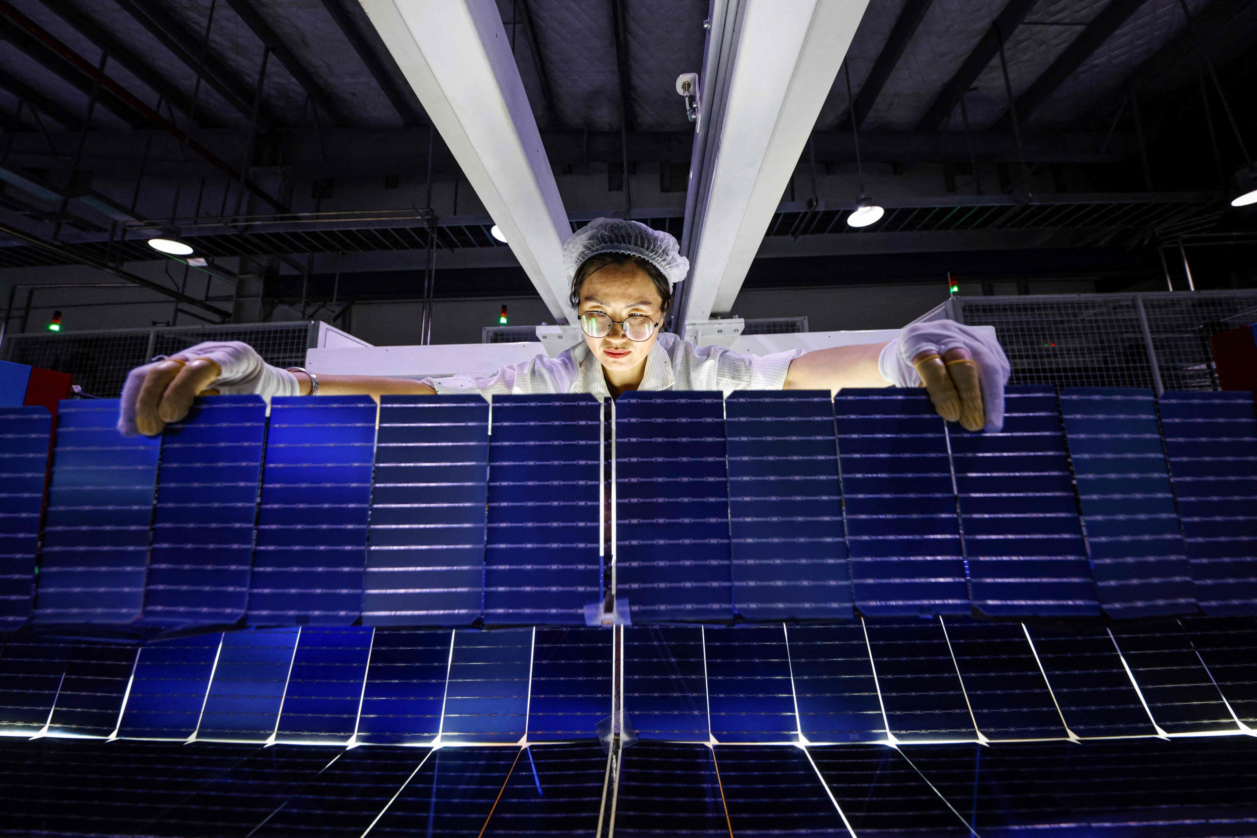 An employee works on solar photovoltaic modules for export at a factory in Sihong, in eastern China’s Jiangsu province on September 3. Photo: AFP