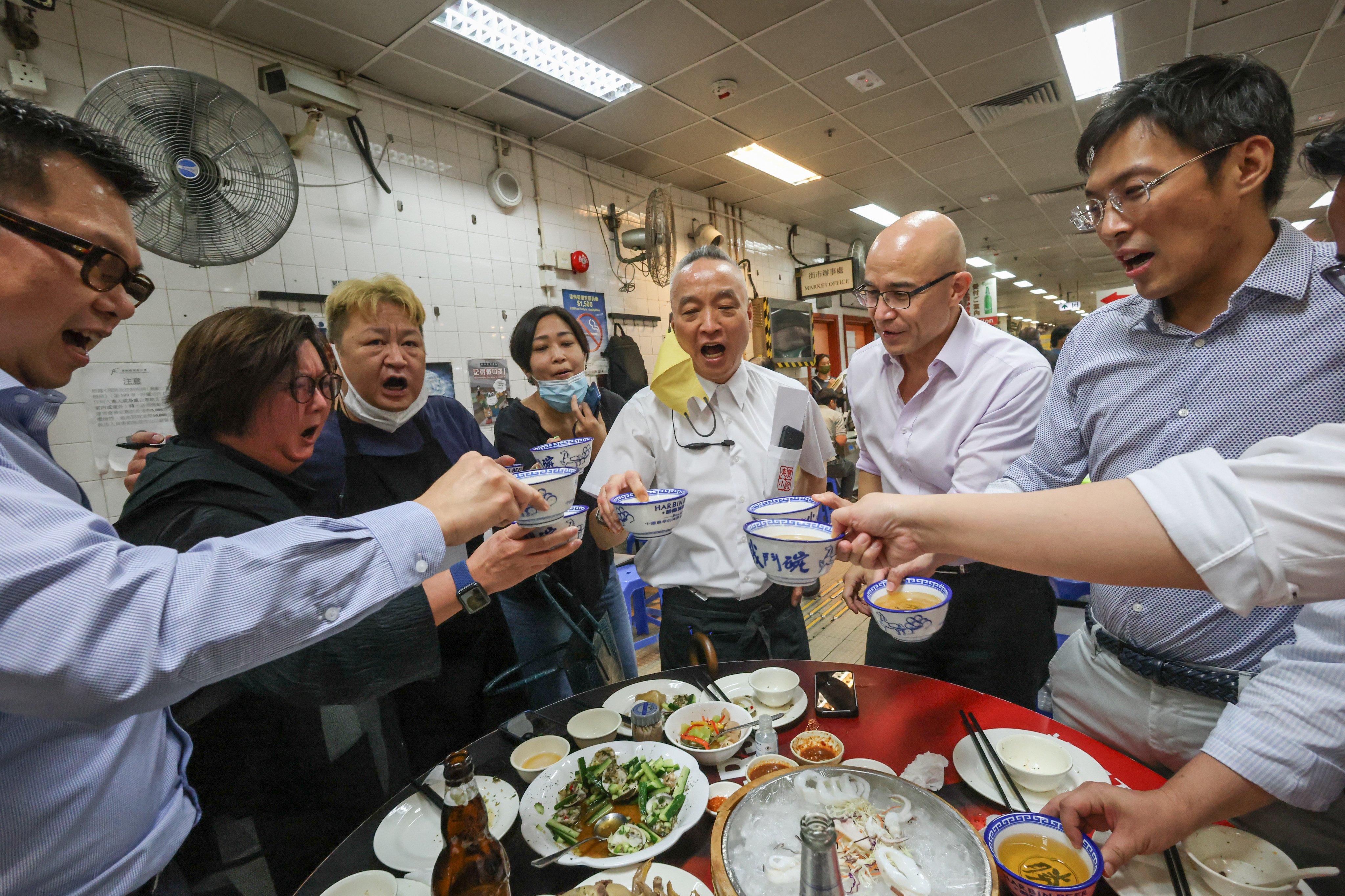 Robby Cheung, manager of Tung Po Kitchen, toasts with customers at Java Road Market and Cooked Food Centre, North Point, Hong Kong, in 2022. Photo: Dickson Lee