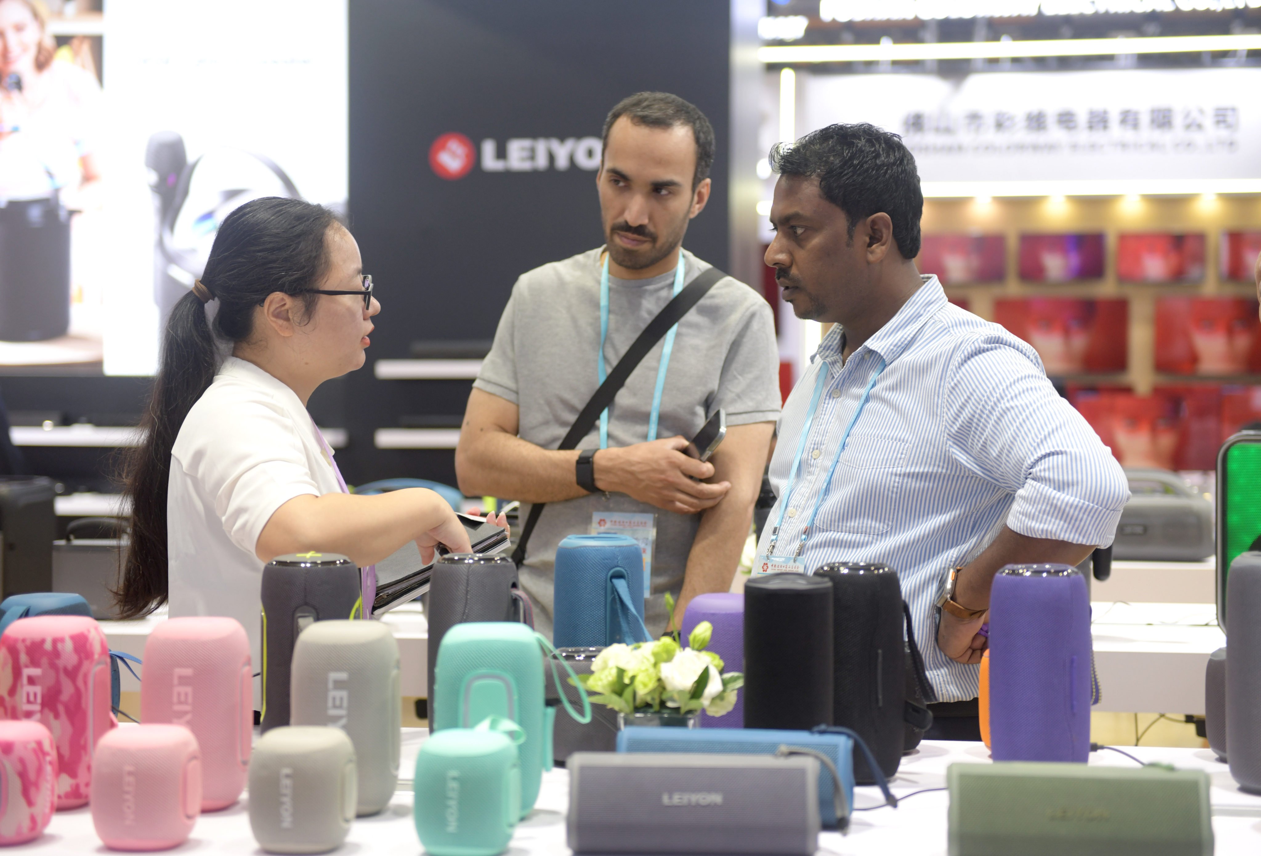 Foreign buyers negotiate business at a booth for audio video equipements during the 136th China Import and Export Fair in Guangzhou. Photo: Xinhua