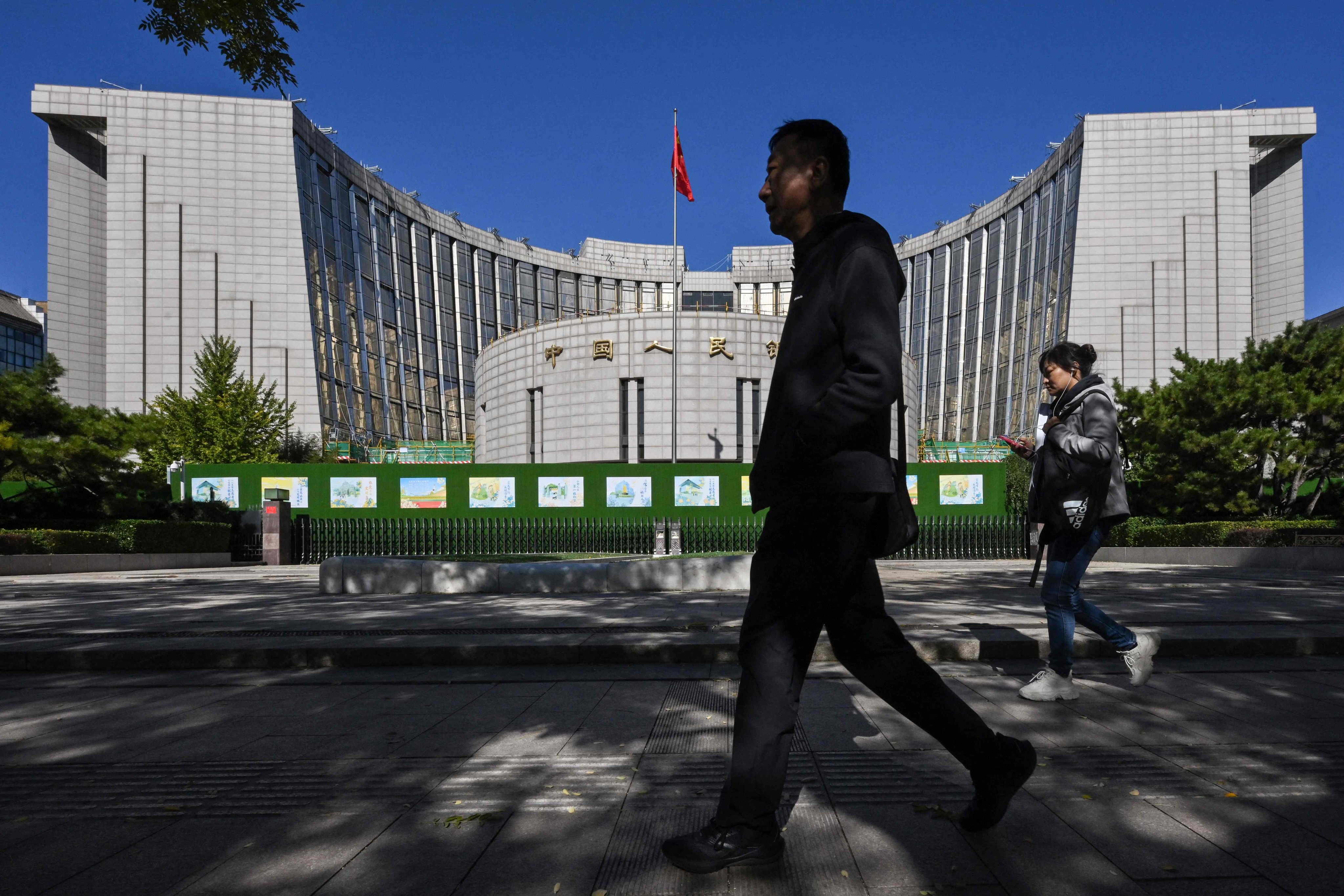 People walk past the People’s Bank of China headquarters in Beijing on Saturday. Photo: AFP