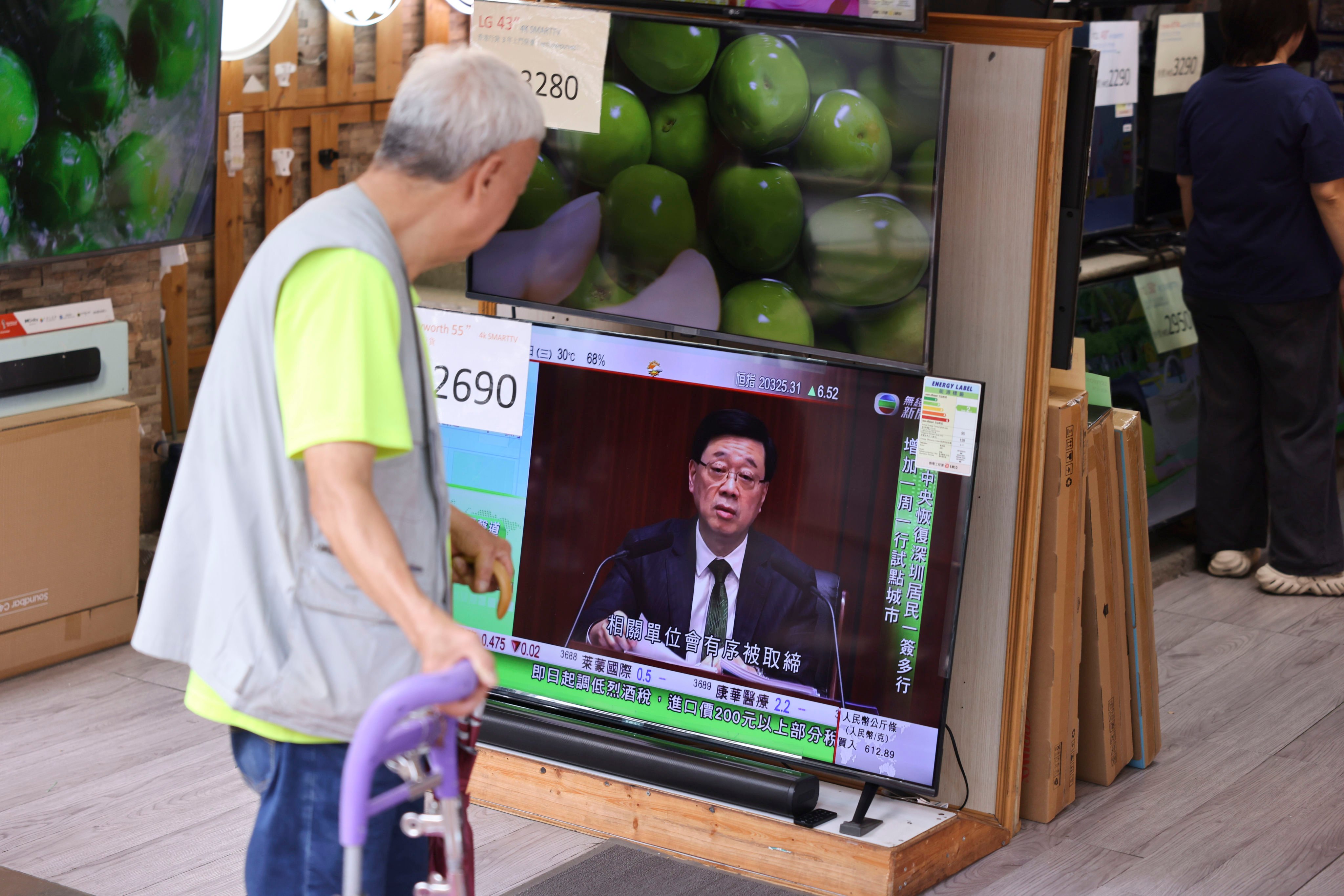 An elderly resident watches a live broadcast of Chief Executive John Lee’s policy address on TV in Sham Shui Po. Photo: Nora Tam