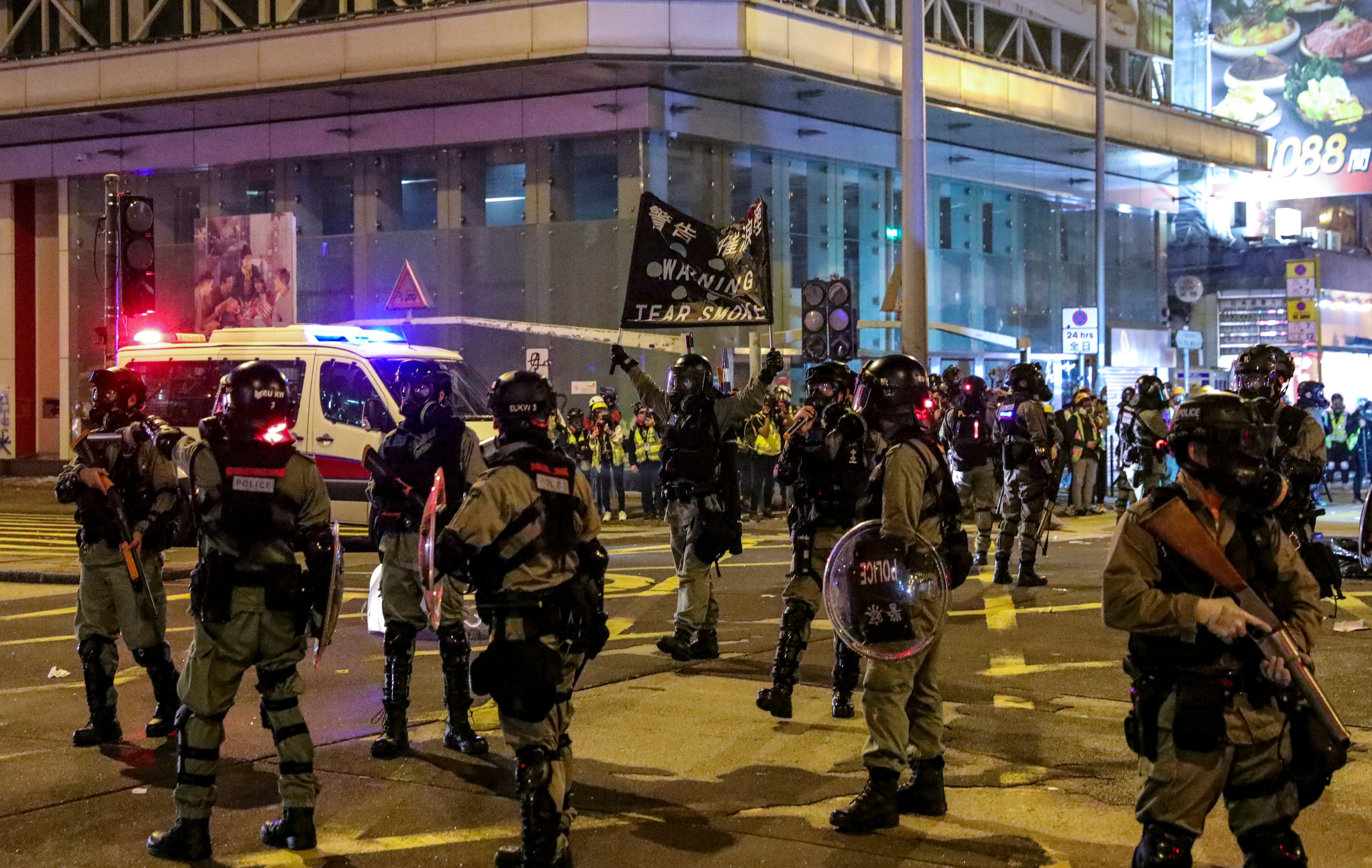 Police hold up a banner to warn demonstrators before firing tear gas in 2019. Photo: May Tse