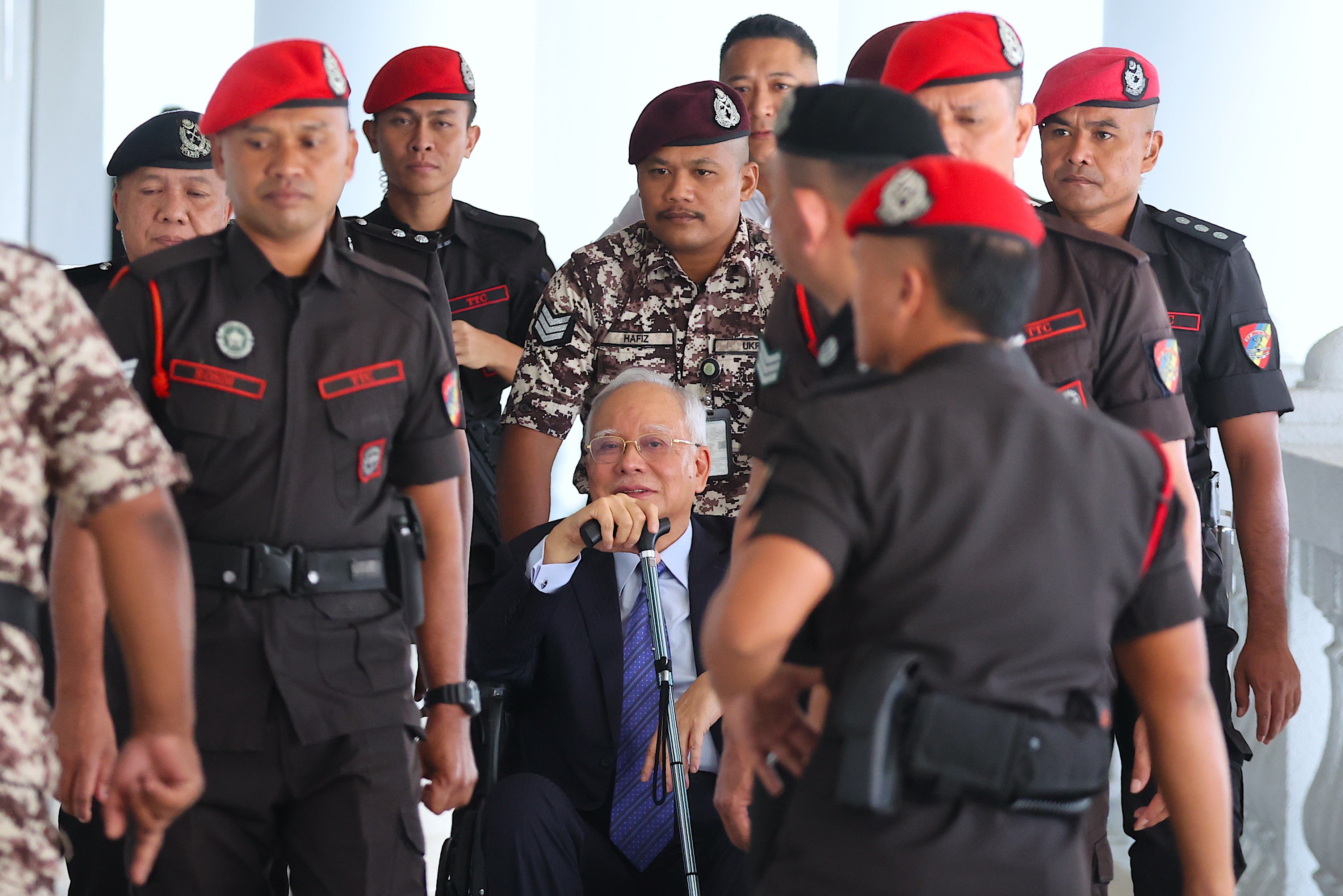 Police officers escort former Malaysian prime minister Najib Razak as he arrives at court for a hearing last month. Photo: EPA-EFE