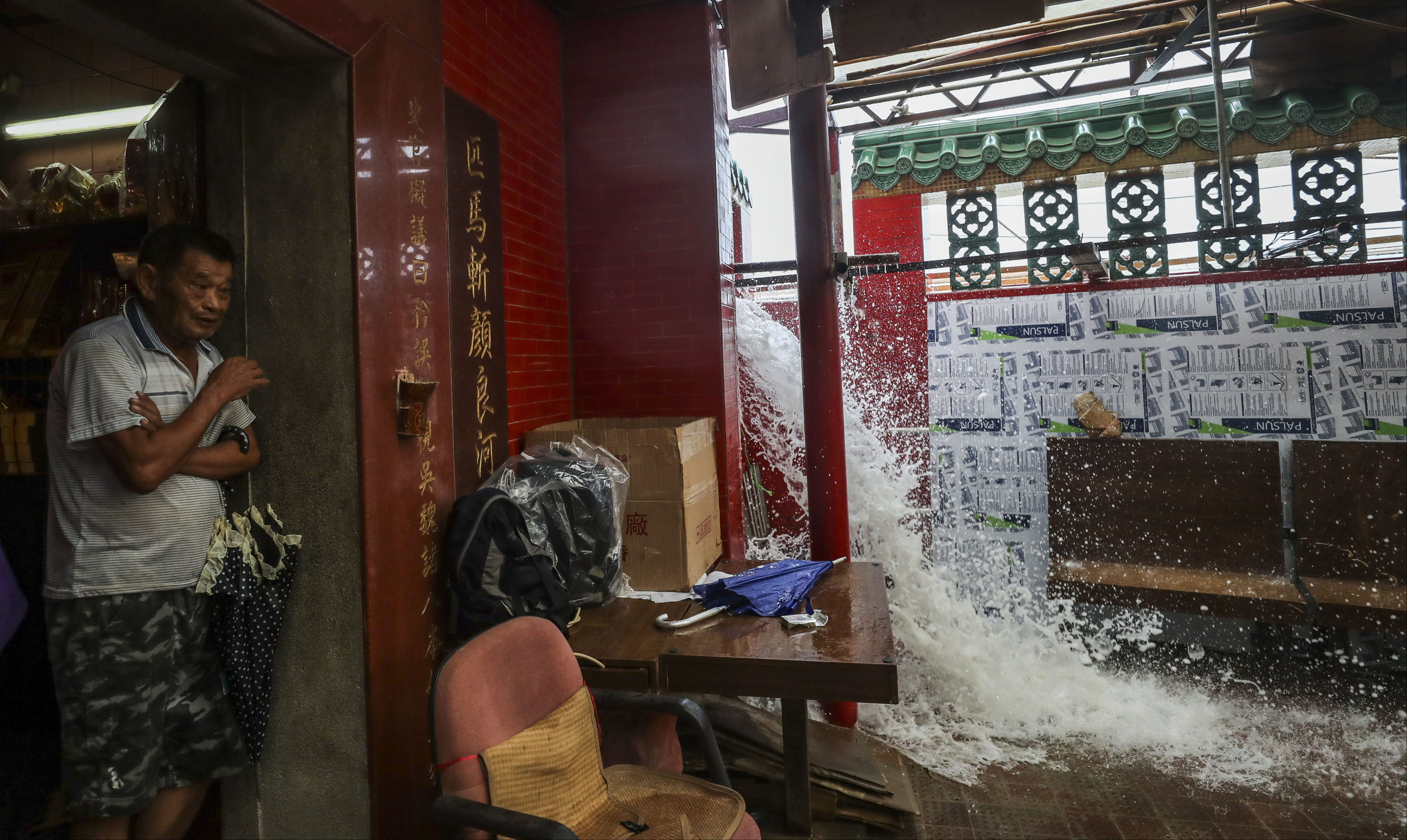 A resident takes shelter at Tin Hau Temple amid strong winds and flooding caused by Typhoon Mangkhut, on September 16, 2018. Photo: Winson Wong