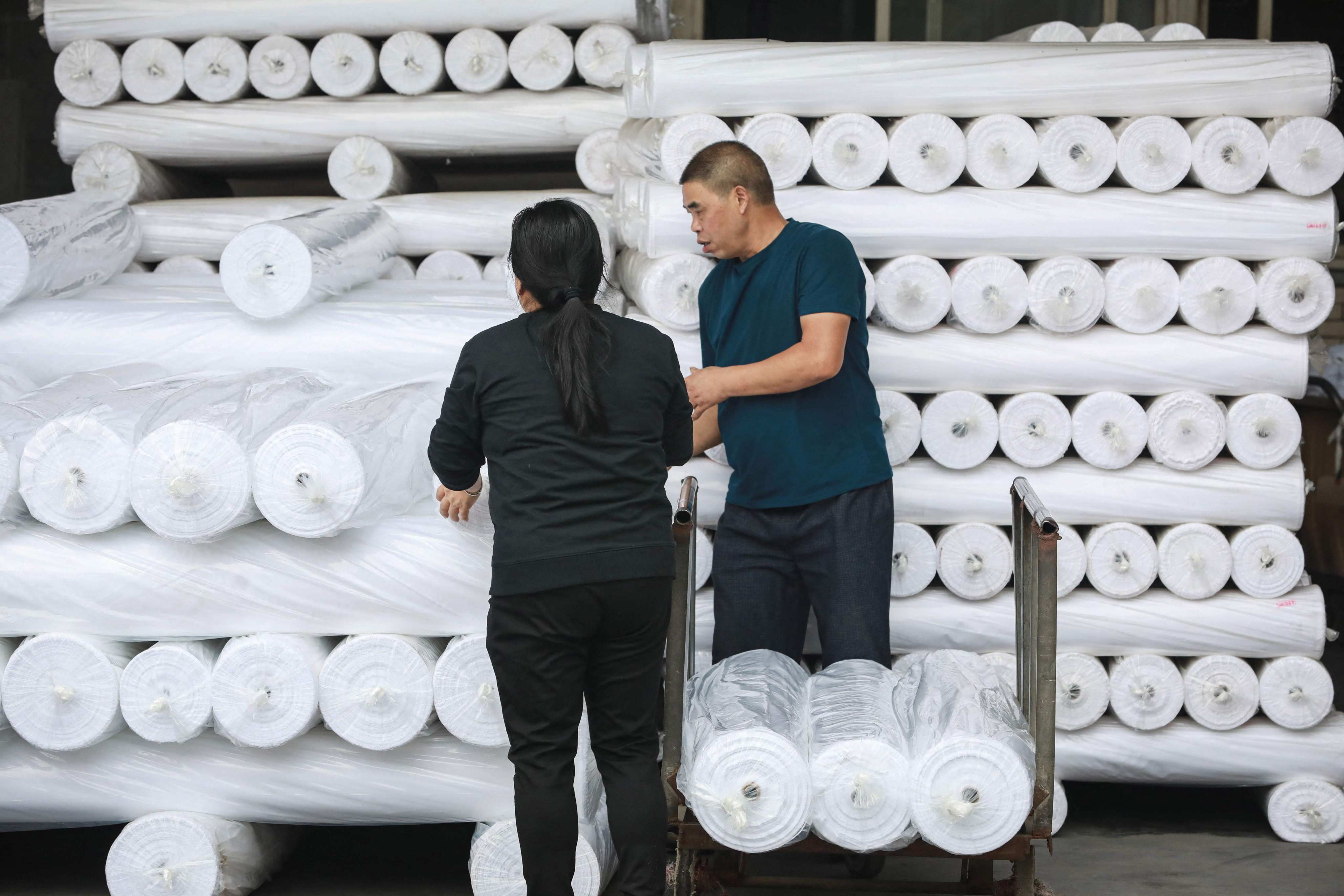 Employees make fabric at a clothing factory in Hangzhou in eastern China’s Zhejiang province. Photo: AFP