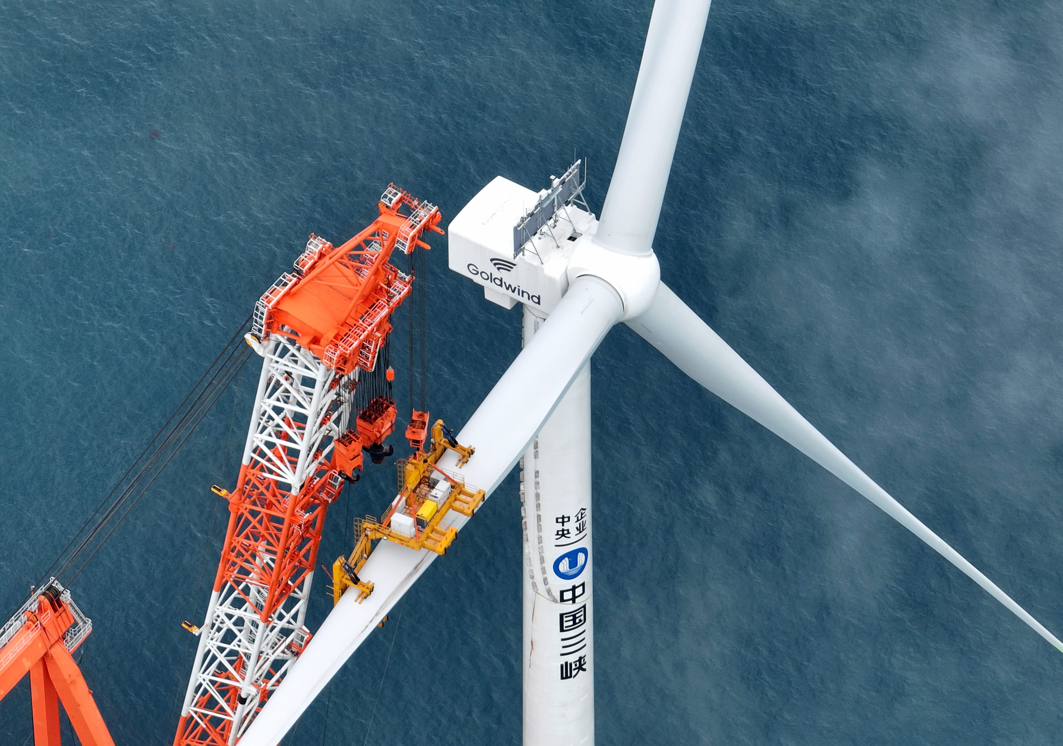 Workers install a blade of a 16-megawatt wind turbine at the Zhangpu wind farm in southeast China’s Fujian province. Photo: Xinhua