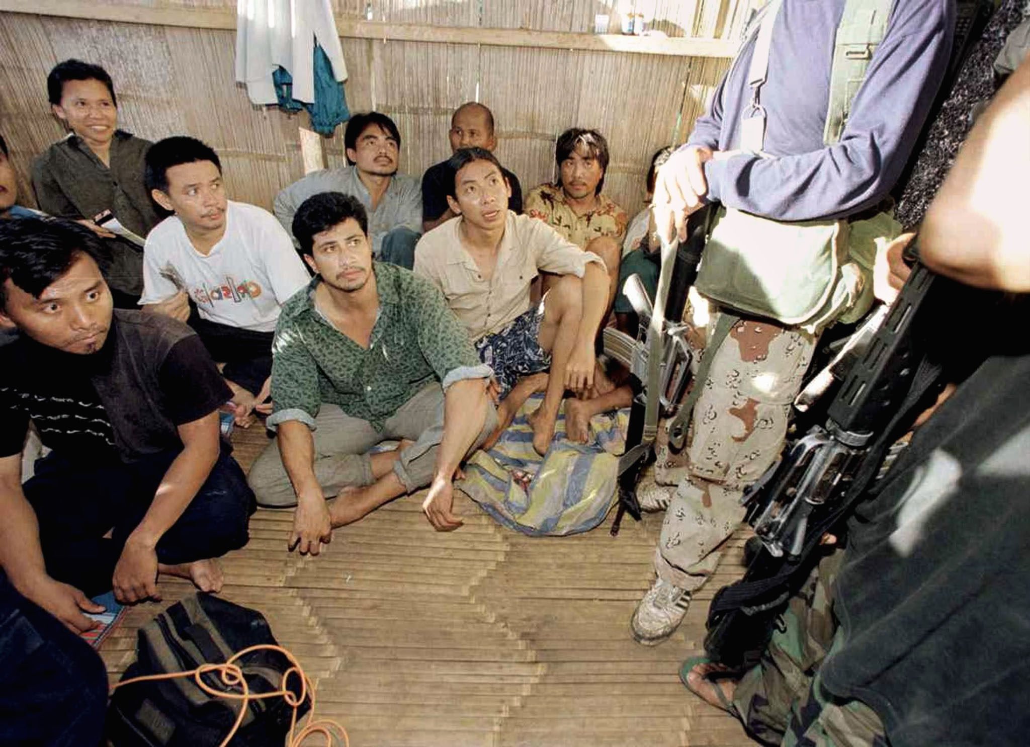 Malaysian hostages are seen being guarded by armed militants at a shack on Jolo Island, southern Philippines, in May 2000. Photo: Reuters