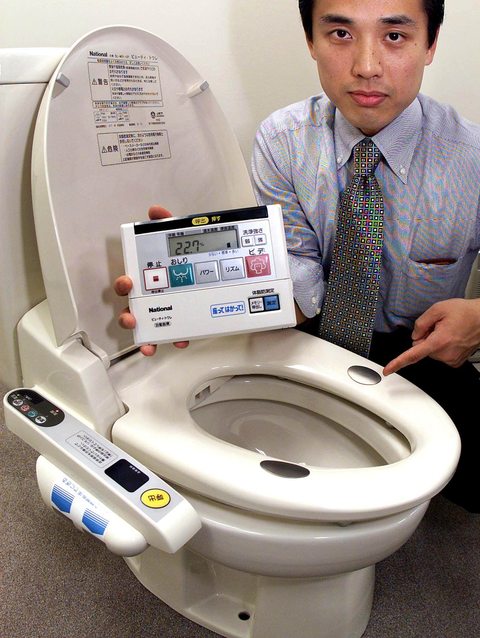 An employee of Japanese electronics giant Matsushita displaying the company’s latest hi-tech toilet seat model in 2002. Photo: AFP