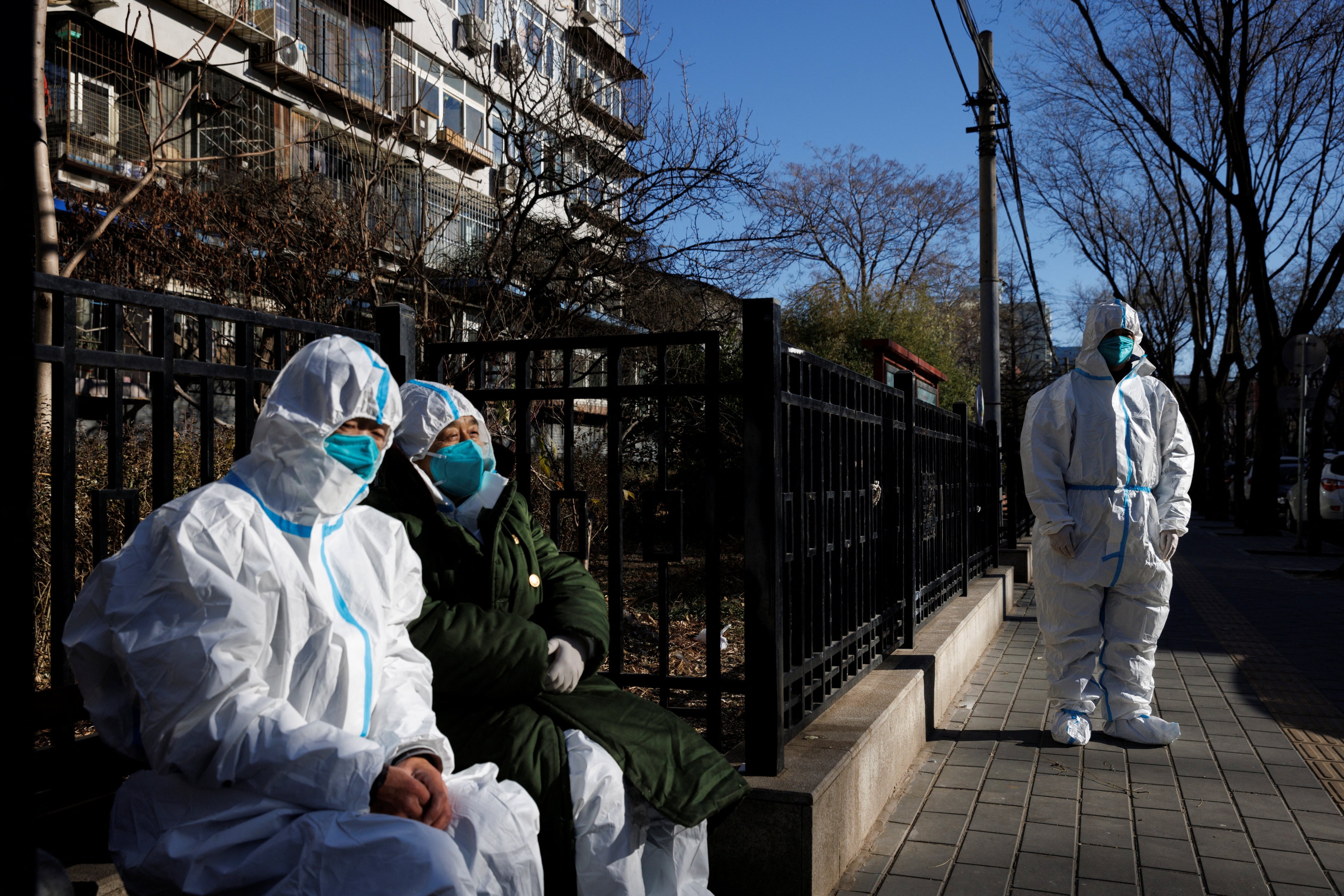 Pandemic control workers in protective suits take a break in Beijing in December 2022. China’s ability to impose widespread Covid control measures is held up as a success story for the system. Photo: Reuters