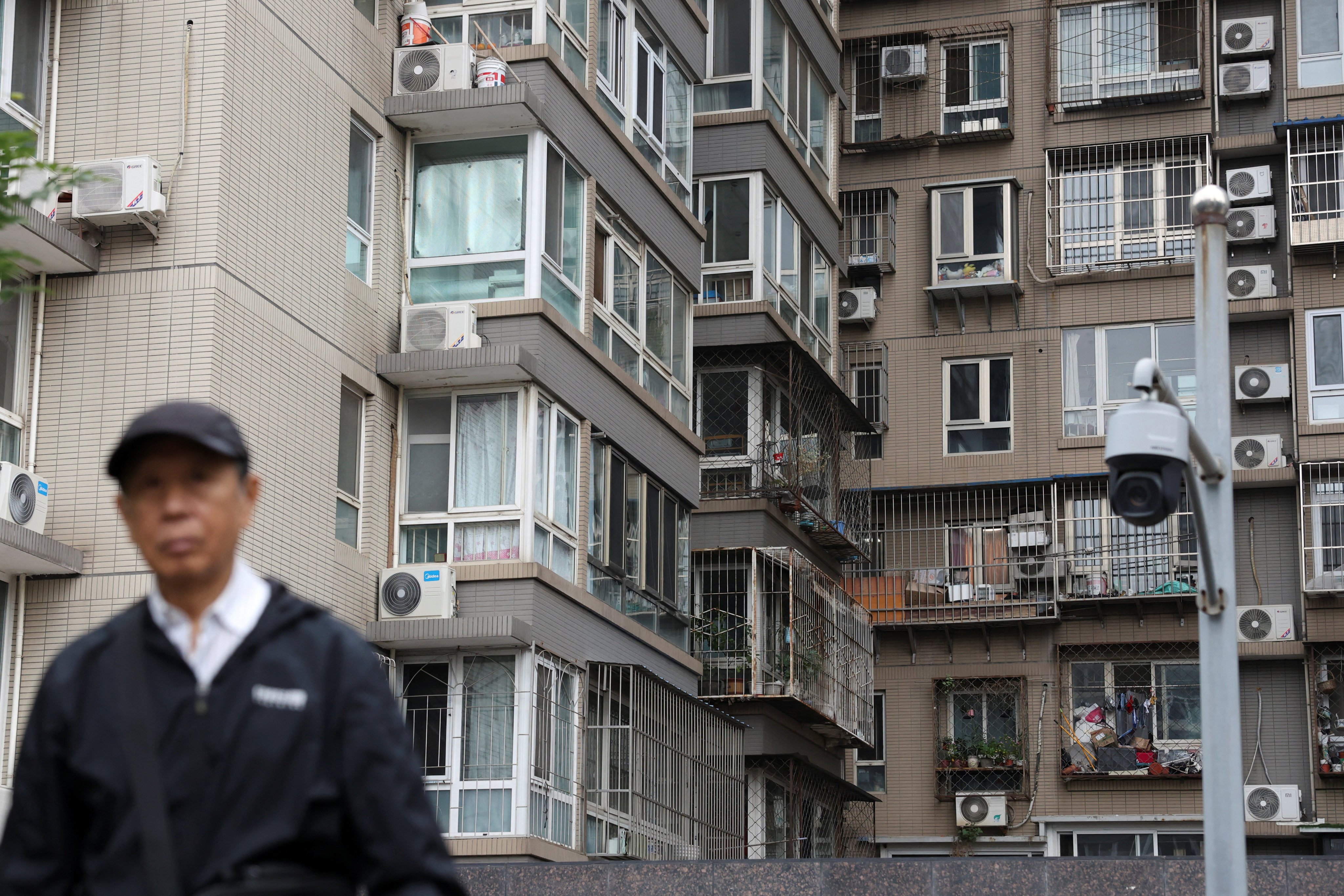 A man walks by residential buildings in Beijing. Photo: Reuters