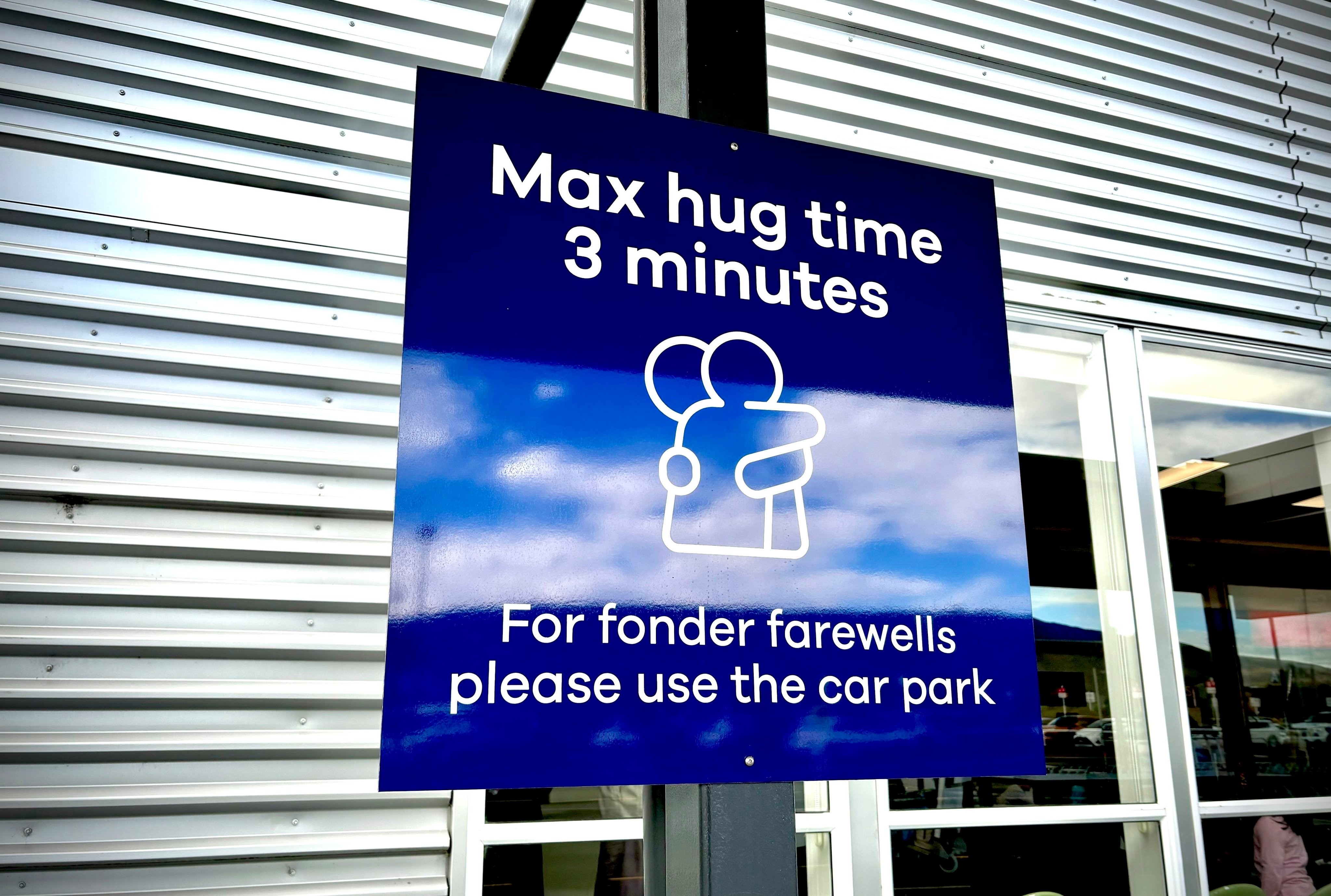 The max hug time sign in New Zealand’s Dunedin Airport went viral on social media, with some criticising it, and others finding it funny. Photo: AP