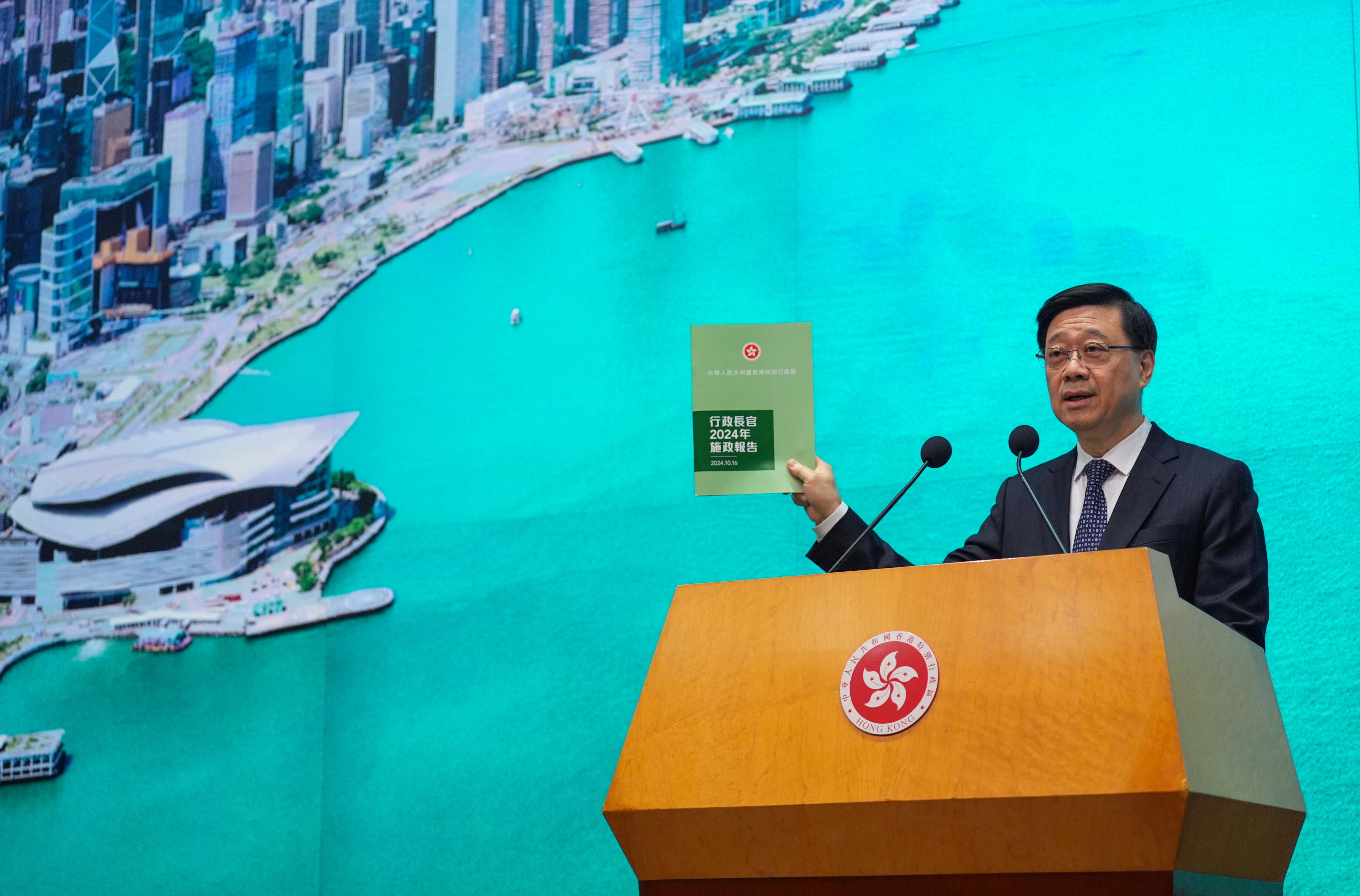 Chief Executive John Lee Ka-chiu holds up a copy of the latest policy address during a press conference at the government’s headquarters in Admiralty on October 15. Lee deliver his third annual policy address on October 16. Photo: Eugene Lee