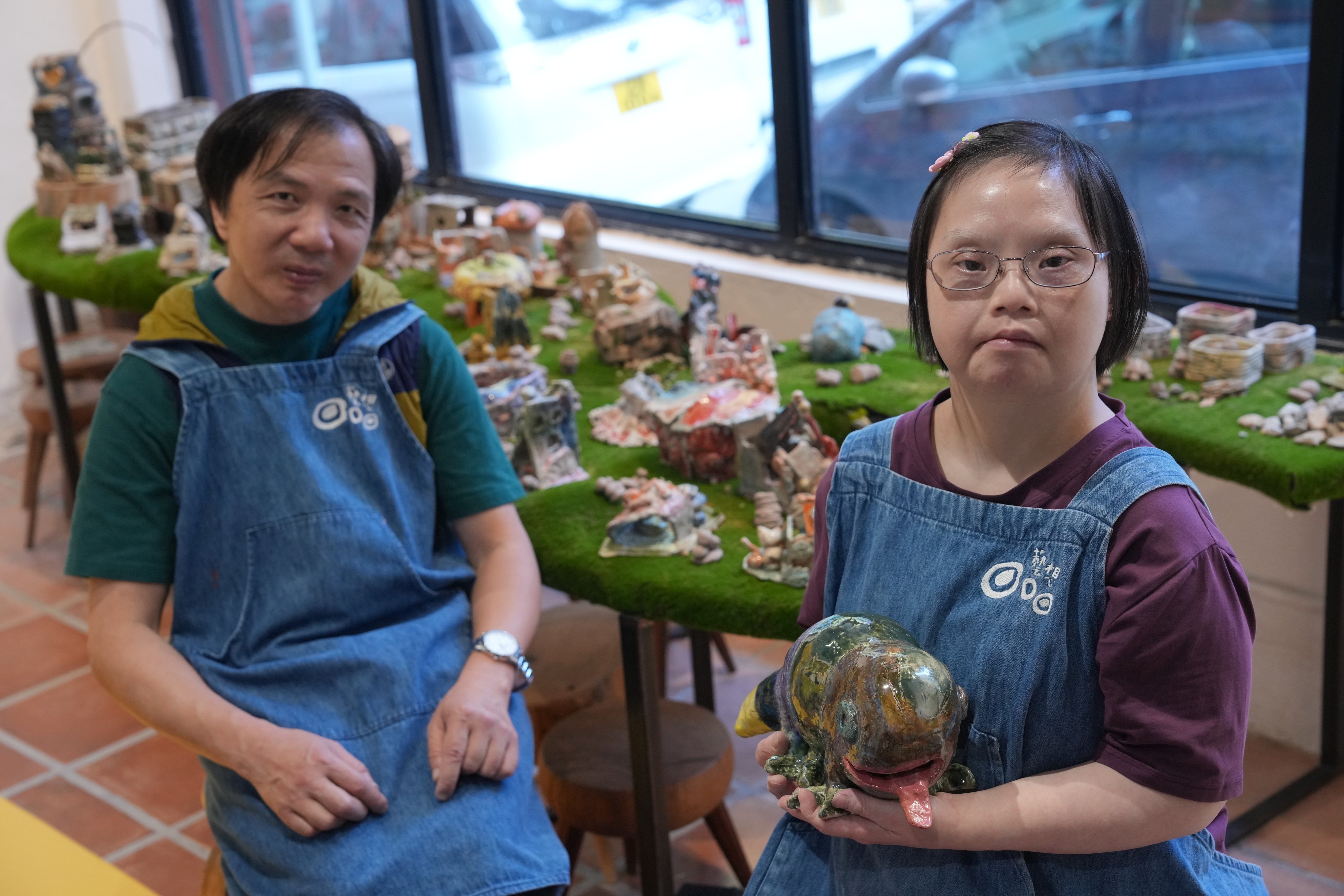 Lam Yuk-ying (left) and Ng Kwok-fai (right) display their ceramic creations at the ‘Morning Relay’ exhibition, which features works by individuals with intellectual disabilities and neurodiverse artists.      08OCT24.     SCMP / May Tse