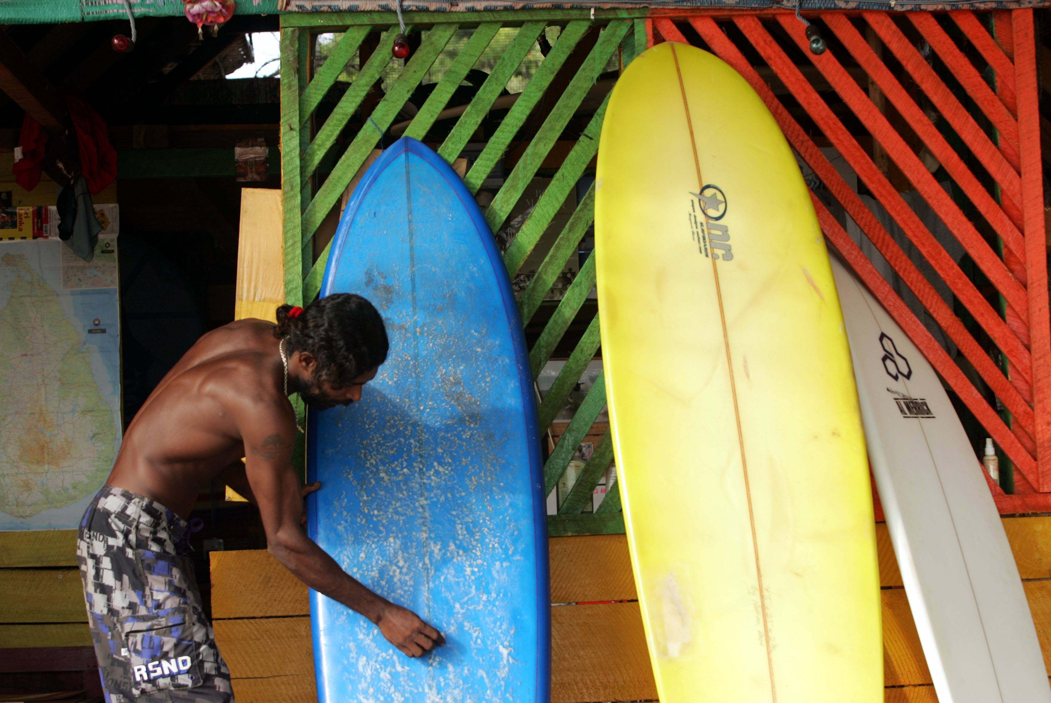 A man cleans surfboards at a rental shop in Arugam Bay, Sri Lanka. Photo: Reuters